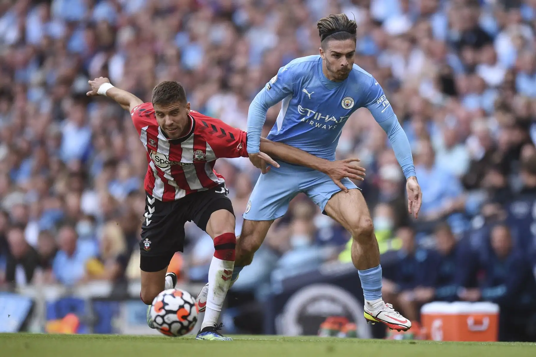 El centrocampista inglés del Manchester City Jack Grealish compite por el balón con el defensor polaco del Southampton Jan Bednarek durante el partido de la Premier League. Foto: AFP