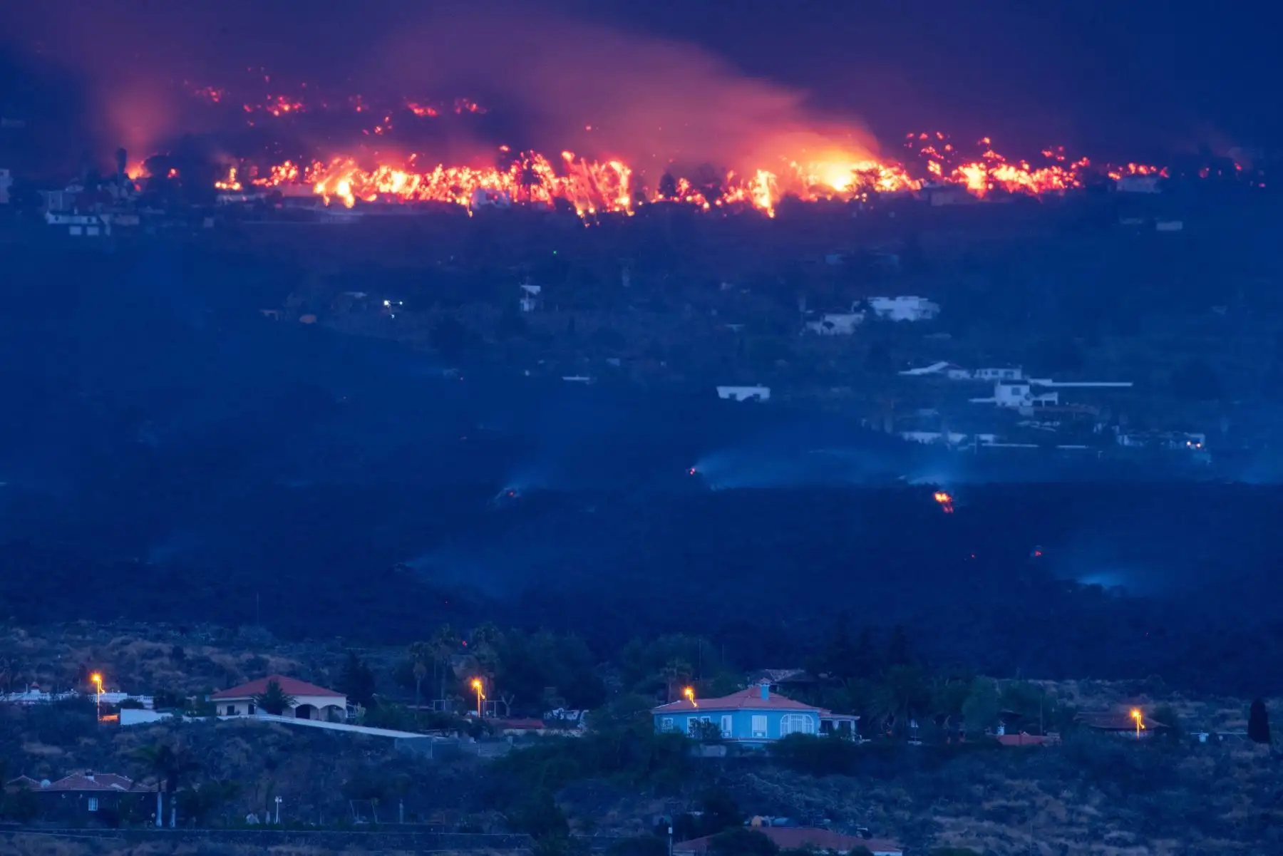 La erupción que comenzó el domingo en La Palma comienza su quinto día de actividad. En la imagen tomada esta madrugada, viviendas amenazadas por la lava en la localidad de Todoque, en el municipio de Los Llanos de Aridane. 
Foto: EFE