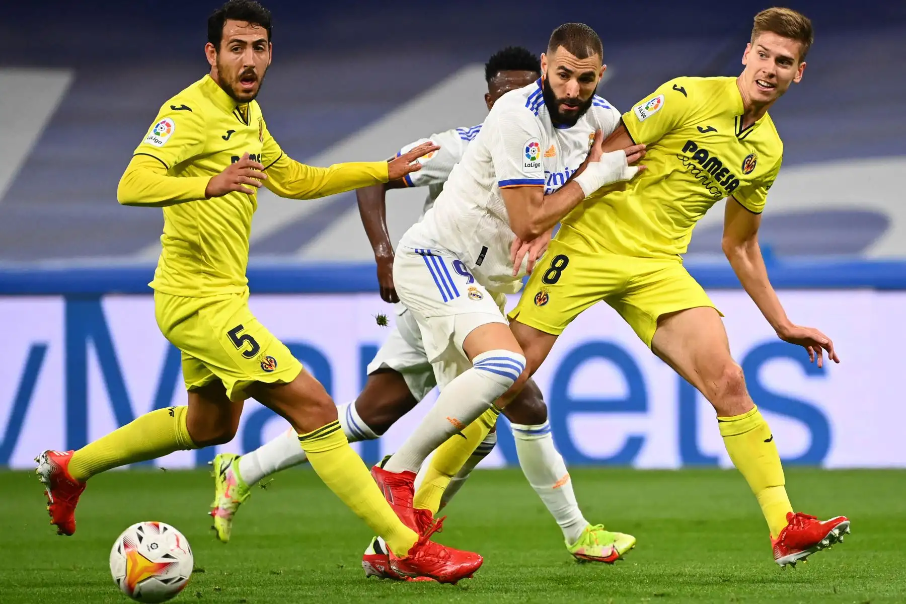 El delantero francés del Real Madrid Karim Benzema compite con el defensor argentino del Villarreal Juan Foyth y el centrocampista español del Villarreal Daniel Parejo durante el partido de fútbol de la Liga española entre el Real Madrid y el Villarreal. Foto: AFP