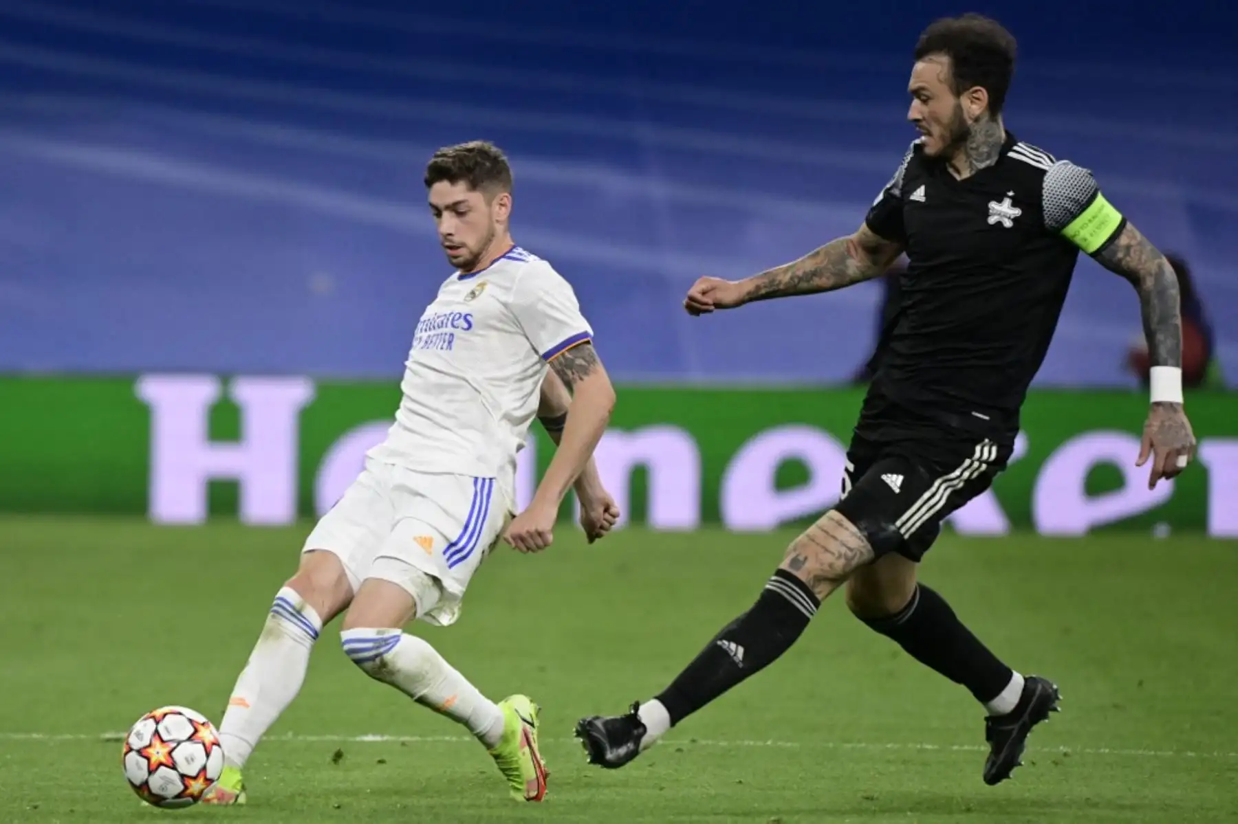 El centrocampista uruguayo del Real Madrid Federico Valverde compite con el defensor peruano del Sheriff Gustavo Dulanto (R) durante el partido de fútbol del grupo D de la primera ronda de la Liga de Campeones de la UEFA entre el Real Madrid y el Sheriff Tiraspol en el estadio Santiago Bernabeu en Madrid, el 28 de septiembre de 2021. Foto: AFP