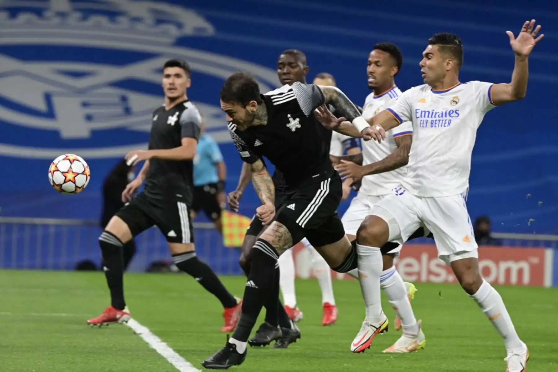 El defensor peruano del Sheriff, Gustavo Dulanto compite con el mediocampista brasileño del Real Madrid Casemiro (R) durante la primera ronda de la Liga de Campeones de la UEFA, partido de fútbol del grupo D entre el Real Madrid y el Sheriff Tiraspol en el estadio Santiago Bernabeu de Madrid, el 28 de septiembre de 2021. Foto: AFP
