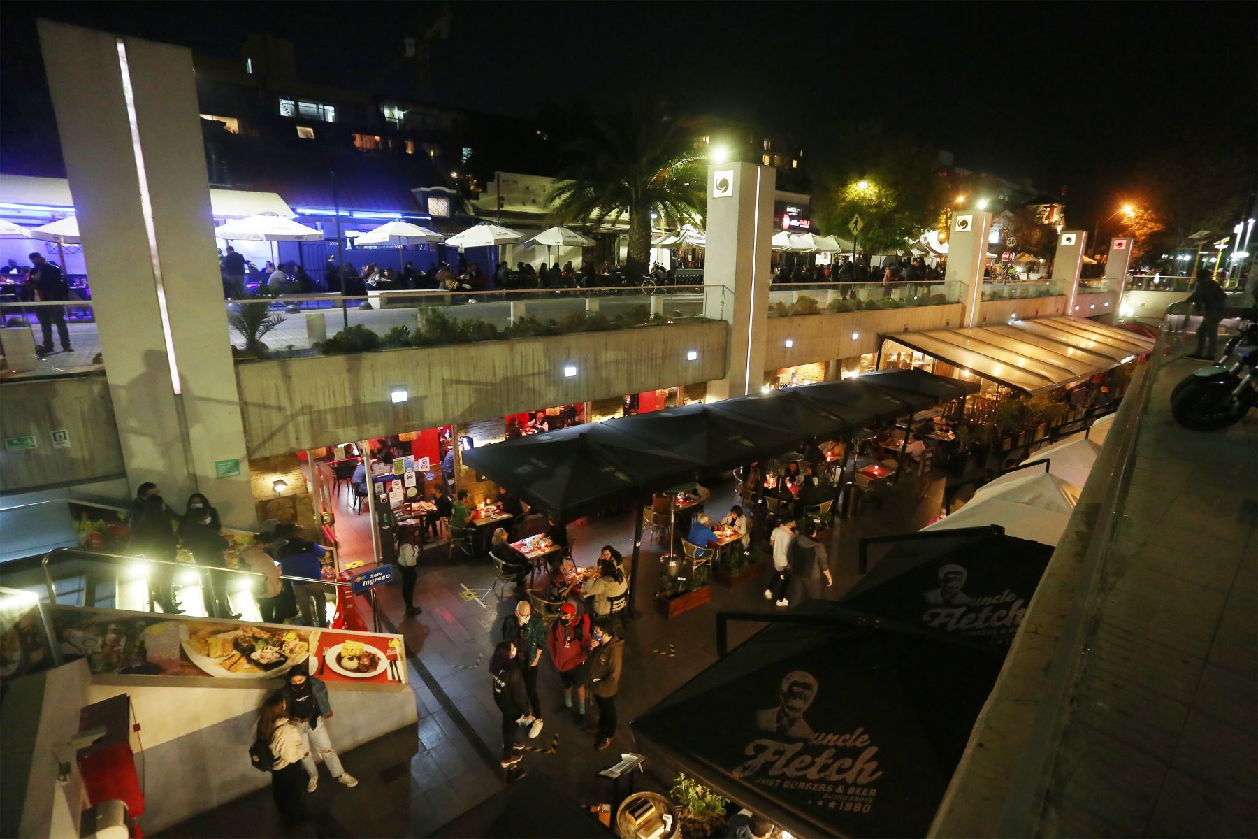 Comercios de Santiago volvieron a lucir con público hasta la medianoche, con el fin del toque de queda. Foto: Efe.