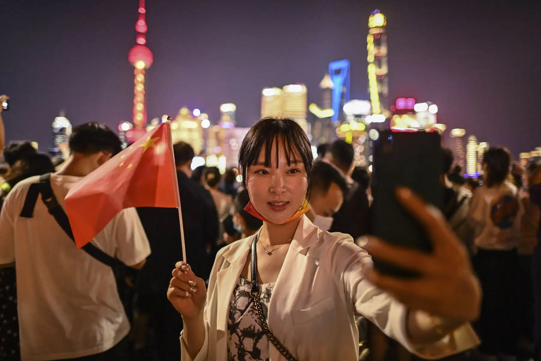 Una mujer se toma una selfie mientras la gente se reúne en el Bund a lo largo del río Huangpu durante el día nacional de China que marca el 72 aniversario del establecimiento de la República Popular China y el feriado de la "Semana Dorada" del país en Shanghai.

Foto:AFP