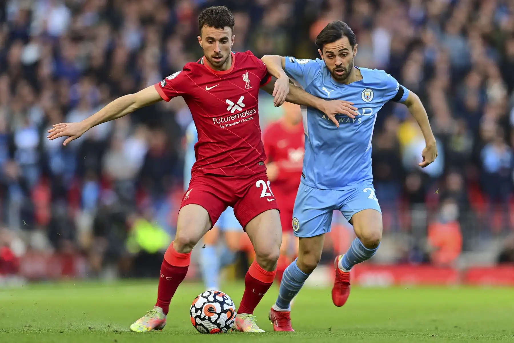 El centrocampista portugués del Manchester City, Bernardo Silva, desafía al delantero portugués del Liverpool, Diogo Jota, durante el partido de la Premier League. Foto: AFP