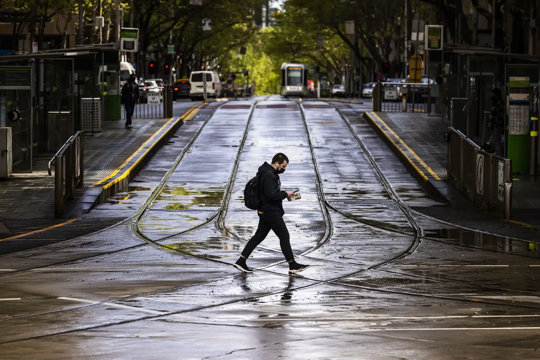 Una persona con mascarilla cruza la calle Collins, en Melbourne, Victoria, Australia. Foto: EFE