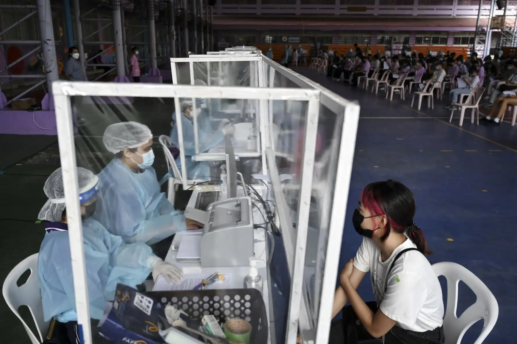 Los trabajadores de la salud registran a los estudiantes de secundaria para recibir la vacuna Pfizer contra el coronavirus en la escuela secundaria Prachaniwet, en Bangkok. Foto: AFP