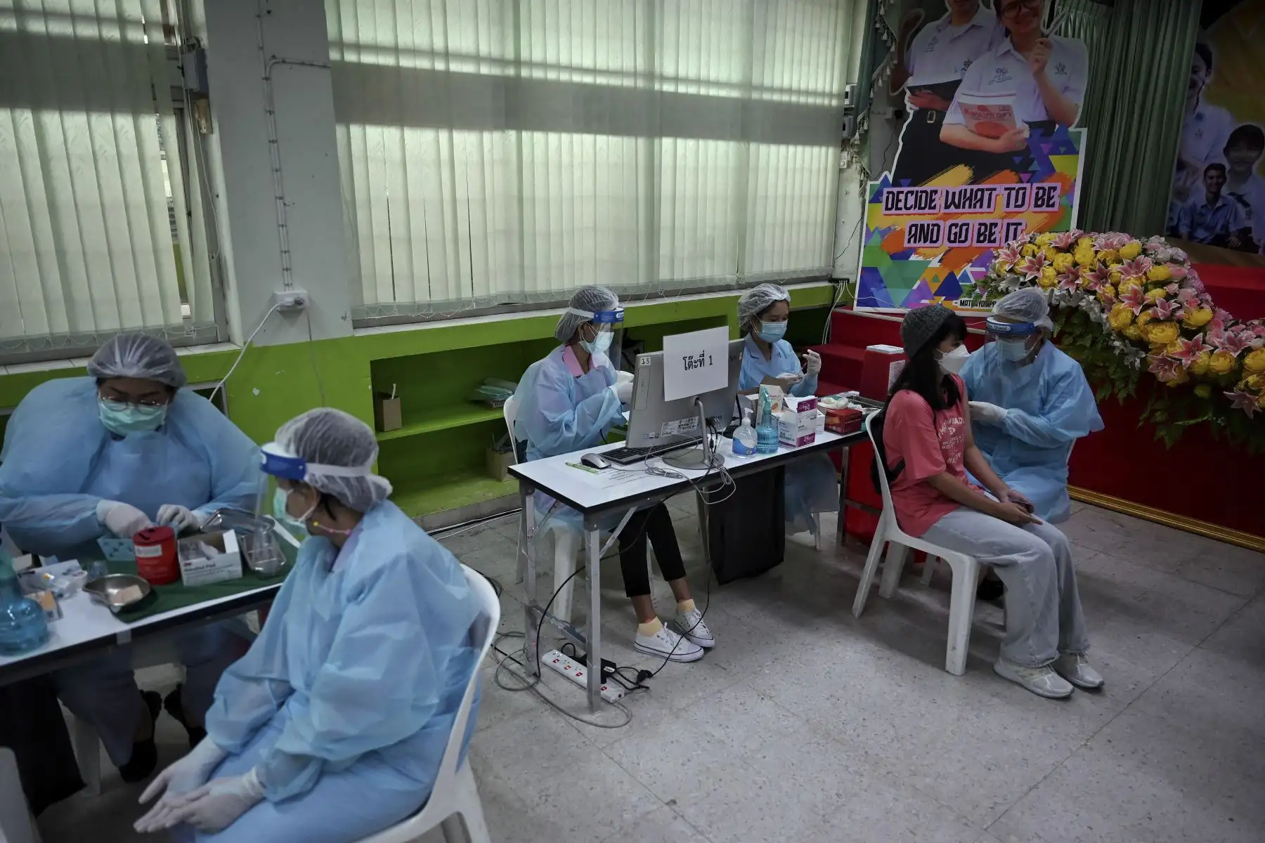Un trabajador de la salud administra la vacuna Pfizer para el coronavirus a un estudiante de secundaria en Prachaniwet, en Bangkok. Foto: AFP