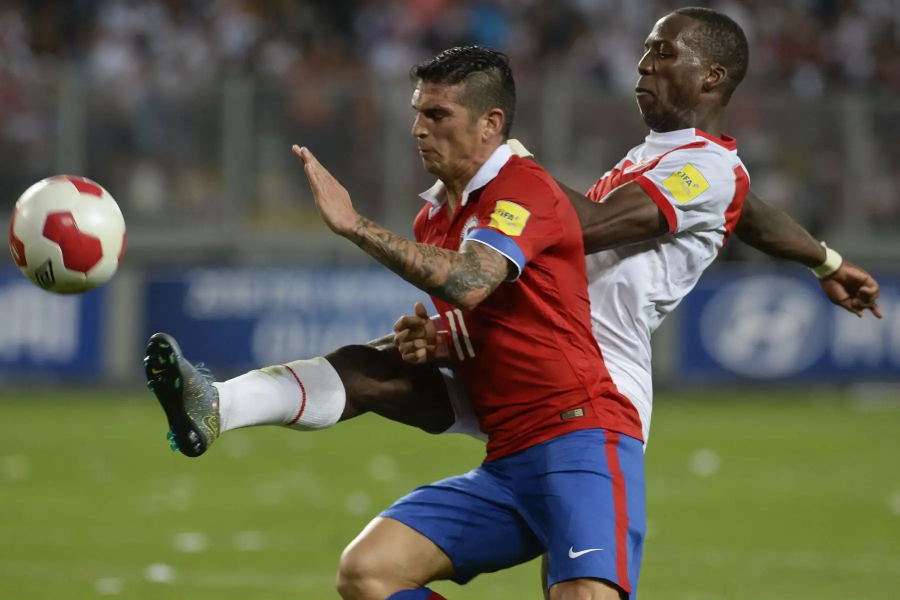 Luis Advíncula  Y el chileno Mark González compiten por el balón durante el partido de fútbol de los Clasificatorios Sudamericanos de la Copa Mundial de la FIFA Rusia 2018, en el Estadio Nacional de Lima.
Foto: AFP