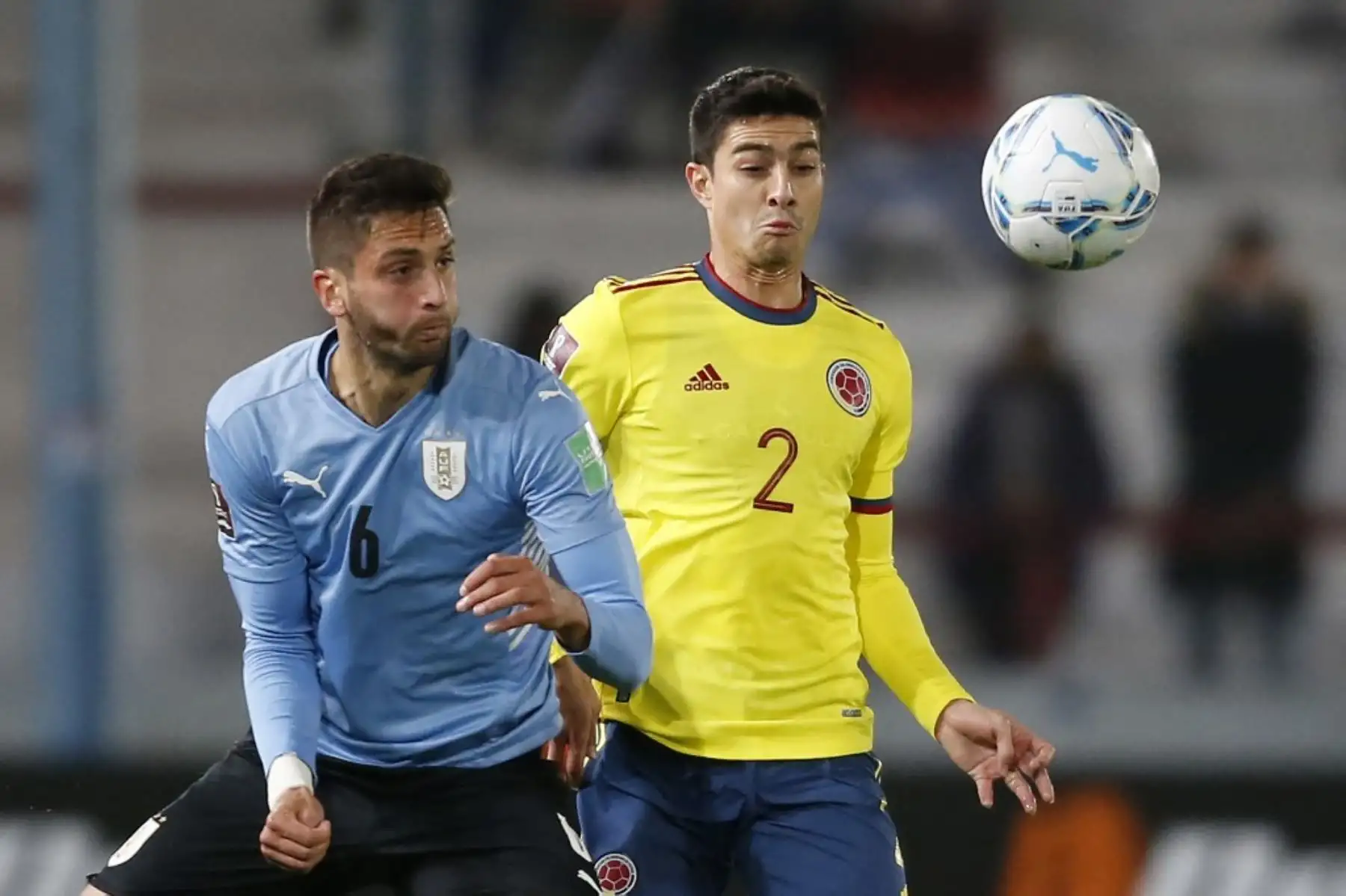 El uruguayo Rodrigo Bentancur (izq.) y el colombiano Stefan Medina compiten por el balón durante su partido de fútbol de clasificación sudamericano para la Copa Mundial de la FIFA Qatar 2022 en el estadio Gran Parque Central de Montevideo el 7 de octubre de 2021. Foto: AFP