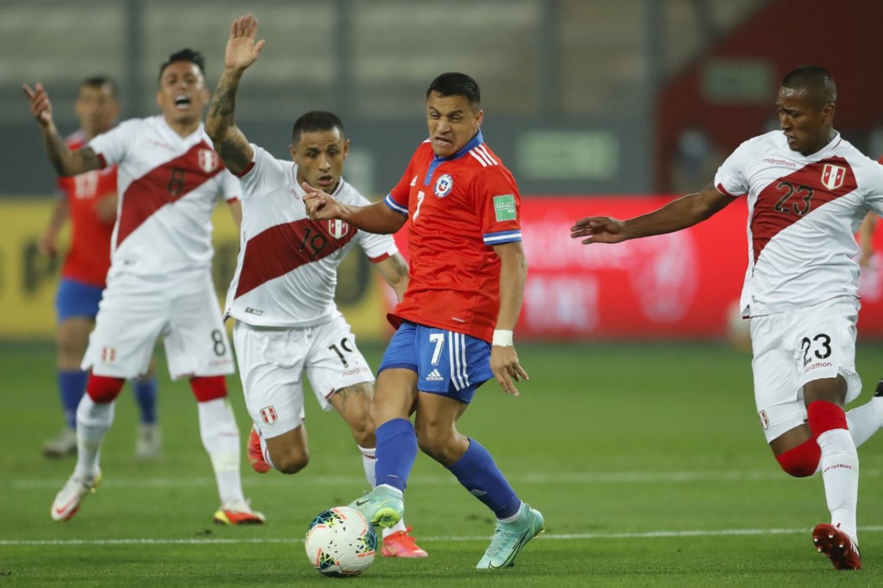 El chileno Alexis Sánchez (C) compite por el balón con los peruanos Yoshimar Yotun (L) y Pedro Aquino (R) durante su partido de fútbol de clasificación sudamericano para la Copa Mundial de la FIFA Qatar 2022 en el Estadio Nacional de Lima el 7 de octubre de 2021. Foto: AFP