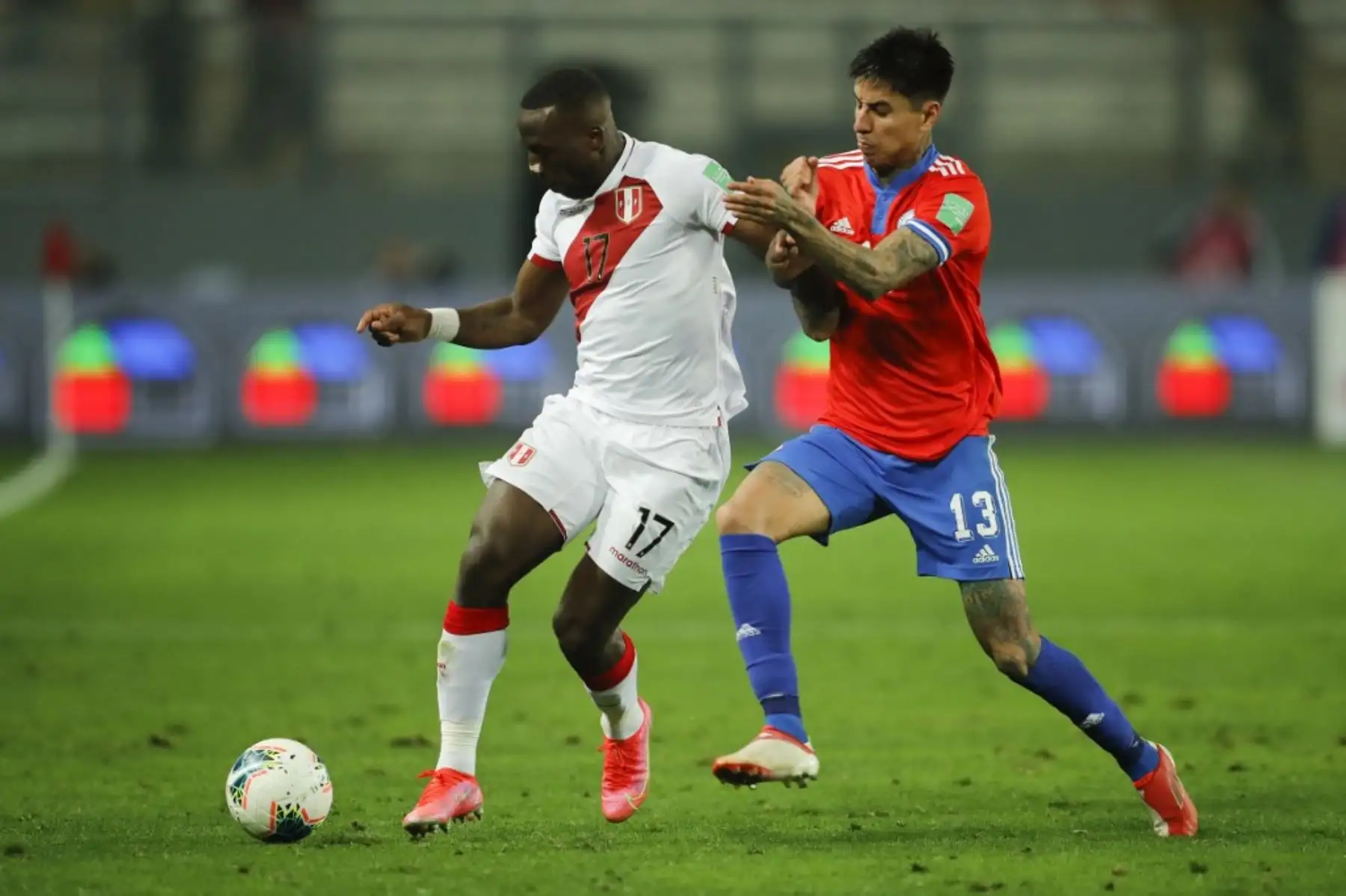 El peruano Luis Advincula (izq.) y el chileno Erick Pulgar (der.) Compiten por el balón durante su partido de fútbol de clasificación sudamericano para la Copa Mundial de la FIFA Qatar 2022 en el Estadio Nacional de Lima el 7 de octubre de 2021. Foto: AFP