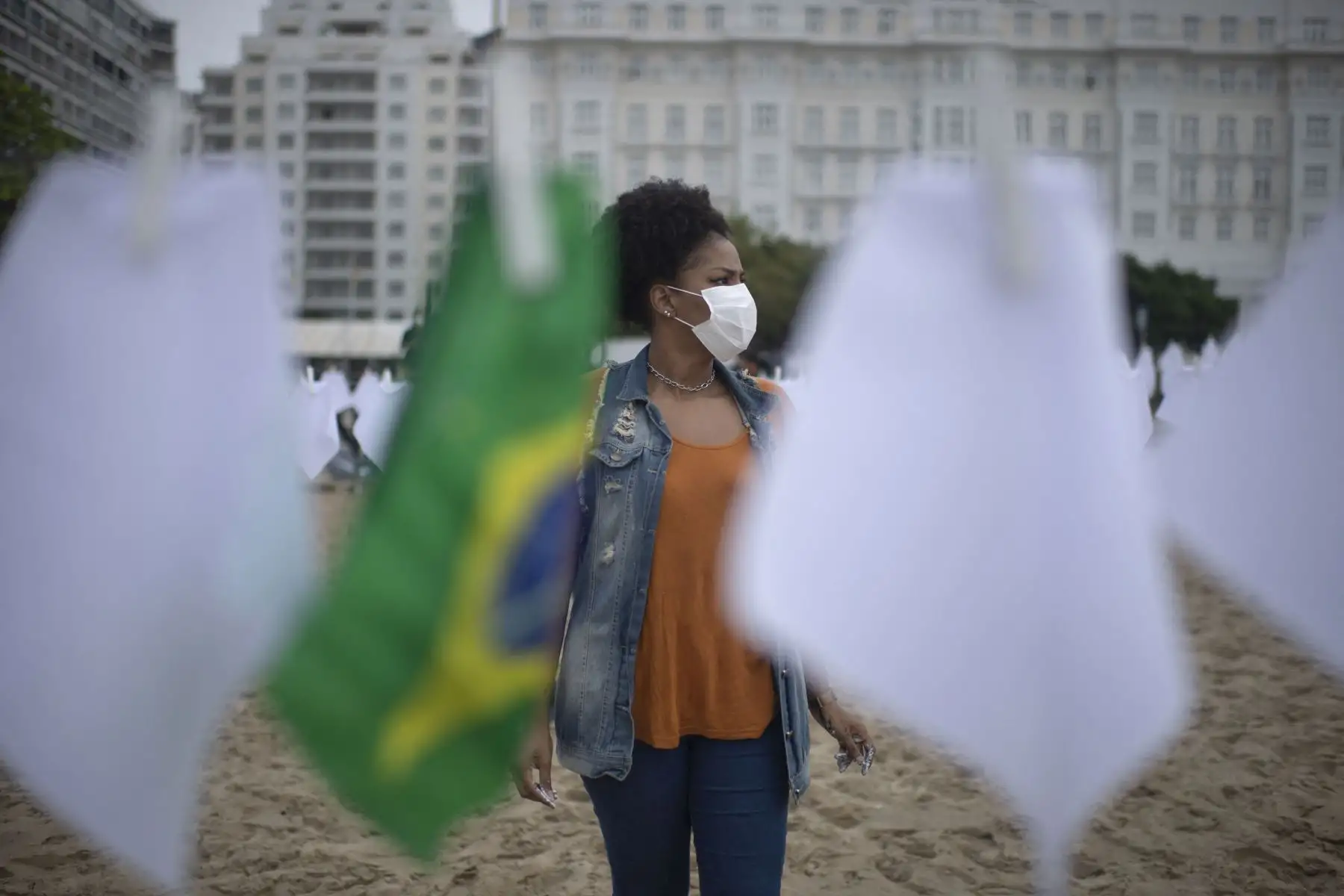 Un manifestante del grupo activista de derechos humanos de Río de Paz cuelga banderas blancas que simbolizan la muerte de casi 600.000 brasileños por el nuevo coronavirus COVID-19, en la playa de Copacabana en Río de Janeiro, Brasil. Foto: AFP