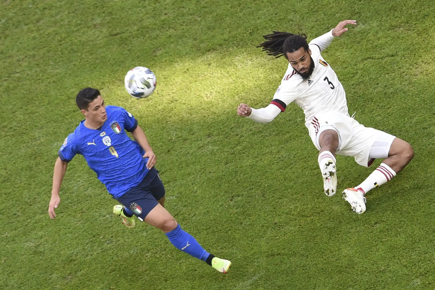 El delantero italiano Giacomo Raspadori pelea por el balón con el defensor belga Jason Denayer durante el partido por el tercer puesto de la Liga de Naciones de la UEFA. Foto: AFP