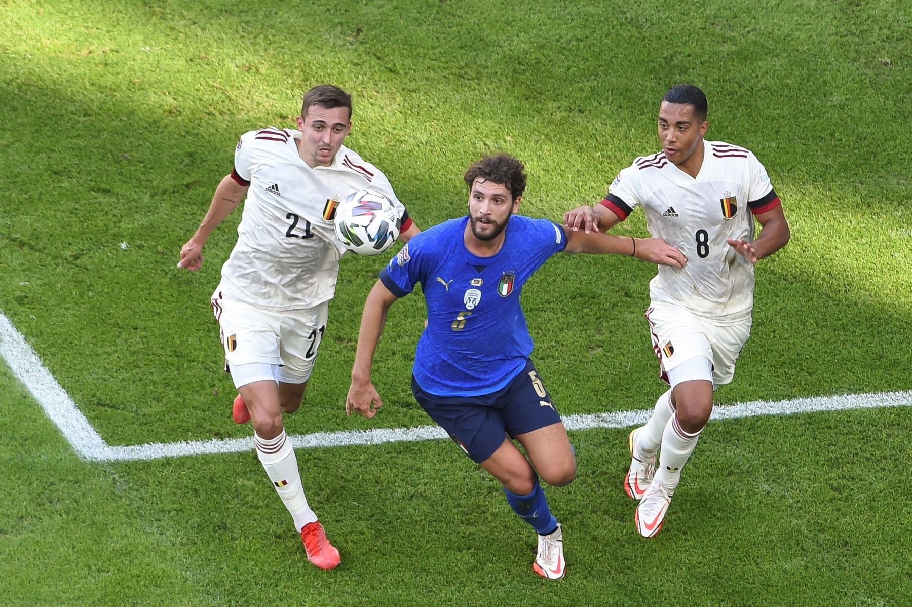 Manuel Locatelli de Italia en acción contra Timothy Castagne y Youri Tielemans de Bélgica durante el partido por el tercer puesto de la UEFA Nations League. Foto: AFP
