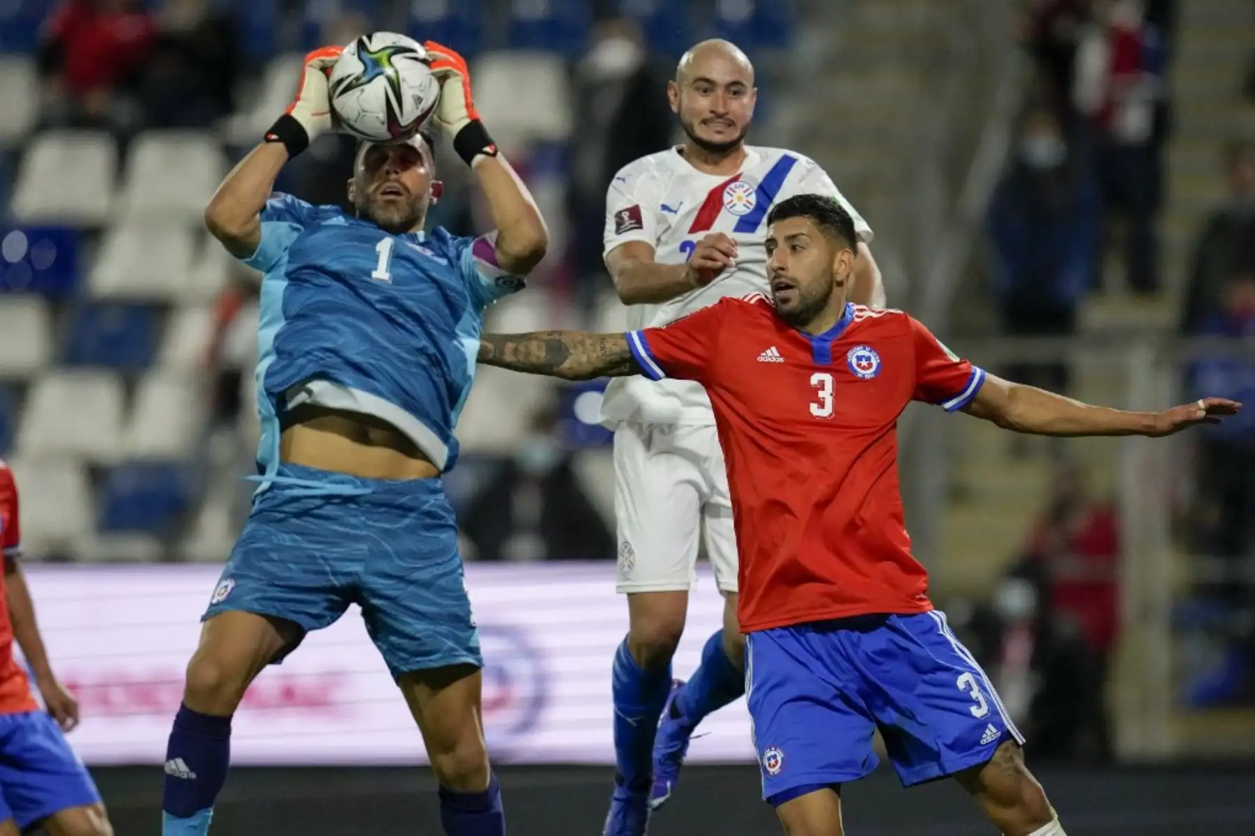 El portero chileno Claudio Bravo (izq.) Atrapa el balón durante el partido clasificatorio sudamericano entre Chile y Paraguay para la Copa Mundial de la FIFA Qatar 2022 en el estadio San Carlos de Apoquindo de Santiago, el 10 de octubre de 2021. Foto: AFP