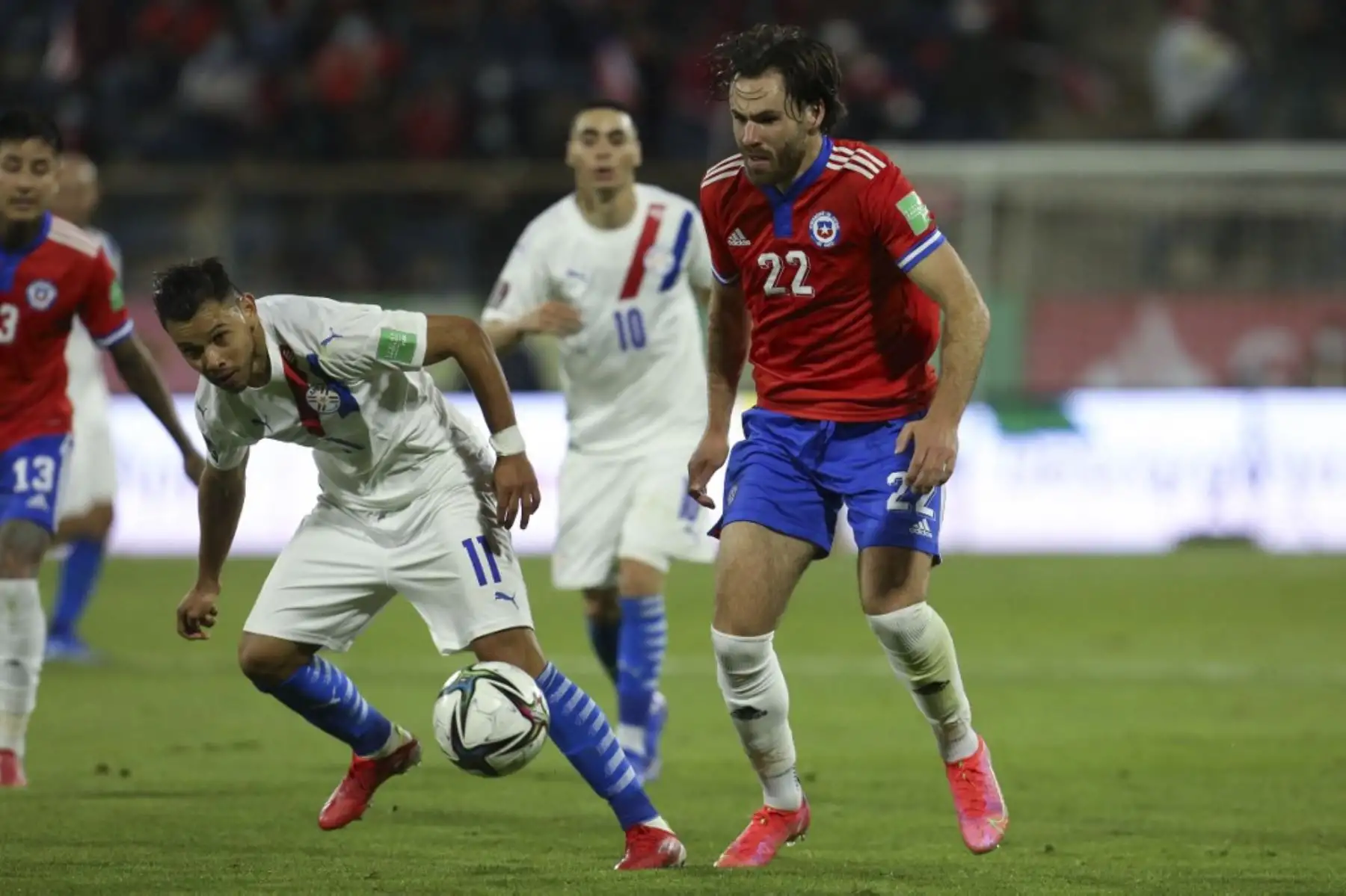 El paraguayo Angel Romero (izq.) Y el chiles Ben Brereton (der.) Compiten por el balón durante el partido clasificatorio sudamericano para la Copa Mundial de la FIFA Qatar 2022 en el estadio San Carlos de Apoquindo de Santiago, el 10 de octubre de 2021. Foto: AFP