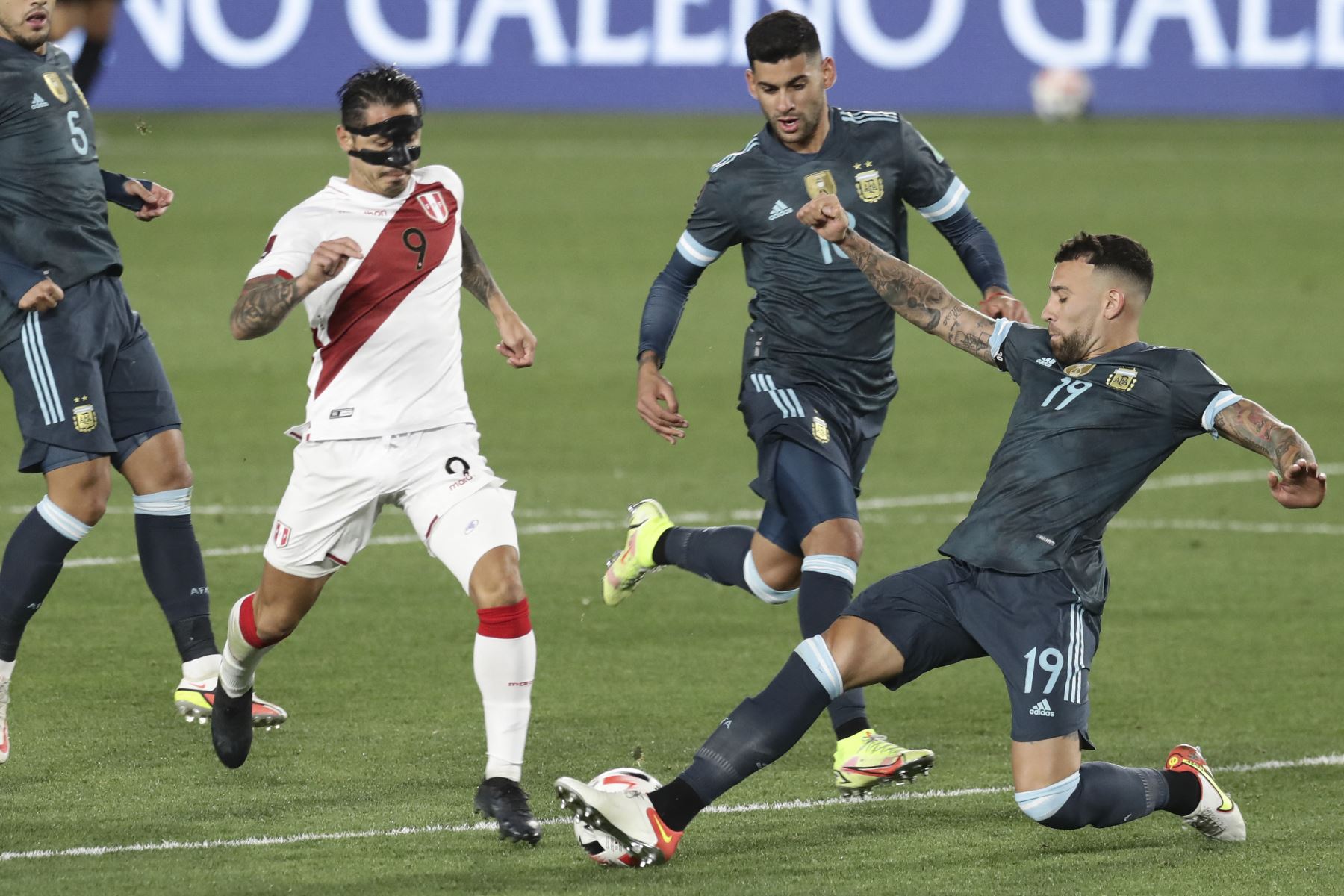 Gianluca Lapadula de Perú disputa un balón ante Guido Rodríguez y Nicolás Otamendi de Argentina durante durante el partido de clasificación sudamericano para la Copa Mundial de la FIFA Catar 2022. Foto: AFP