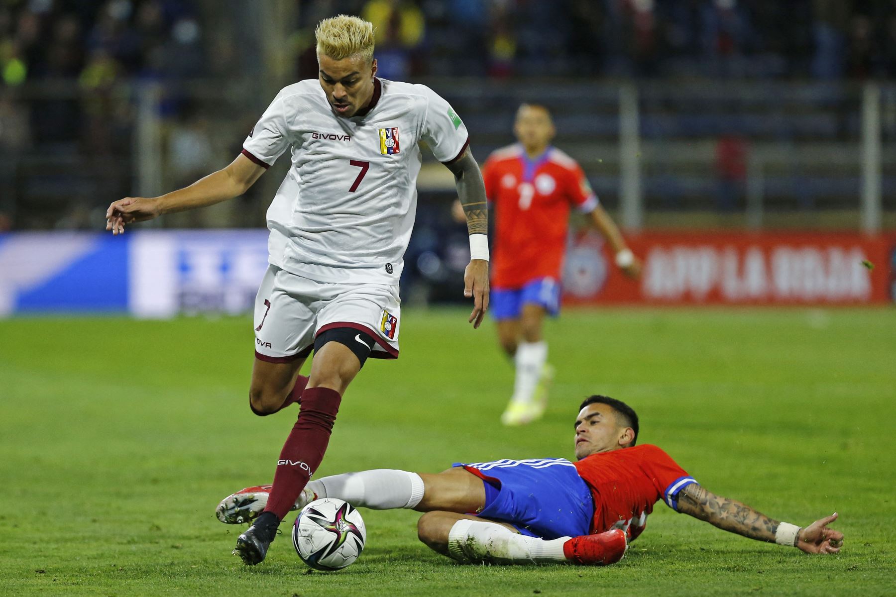 El venezolano Adalberto Peñaranda y el chileno Sebastian Vegas compiten por el balón durante partido de clasificación sudamericano para la Copa Mundial de la FIFA Qatar 2022. Foto: AFP