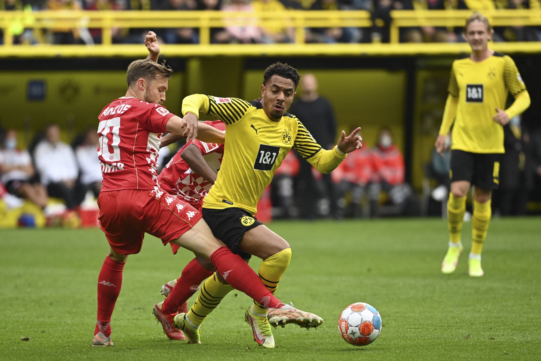 El defensor suizo de Mainz Silvan Widmer y el delantero holandés del Dortmund Donyell Malen compiten por el balón durante el partido de la Bundesliga. Foto: AFP