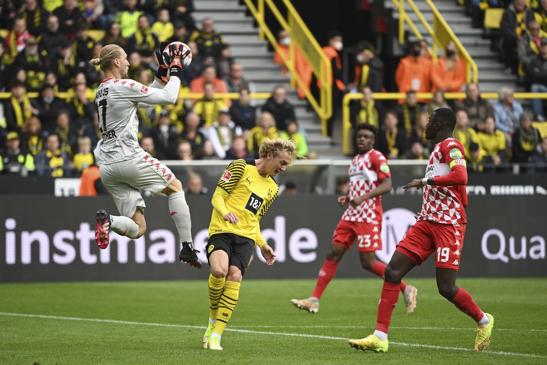 El arquero alemán de Mainz, Robin Zentner, ataja el balón ante la presión de su rival del Dortmund, Julian Brandt, durante el partido de la Bundesliga. Foto: AFP