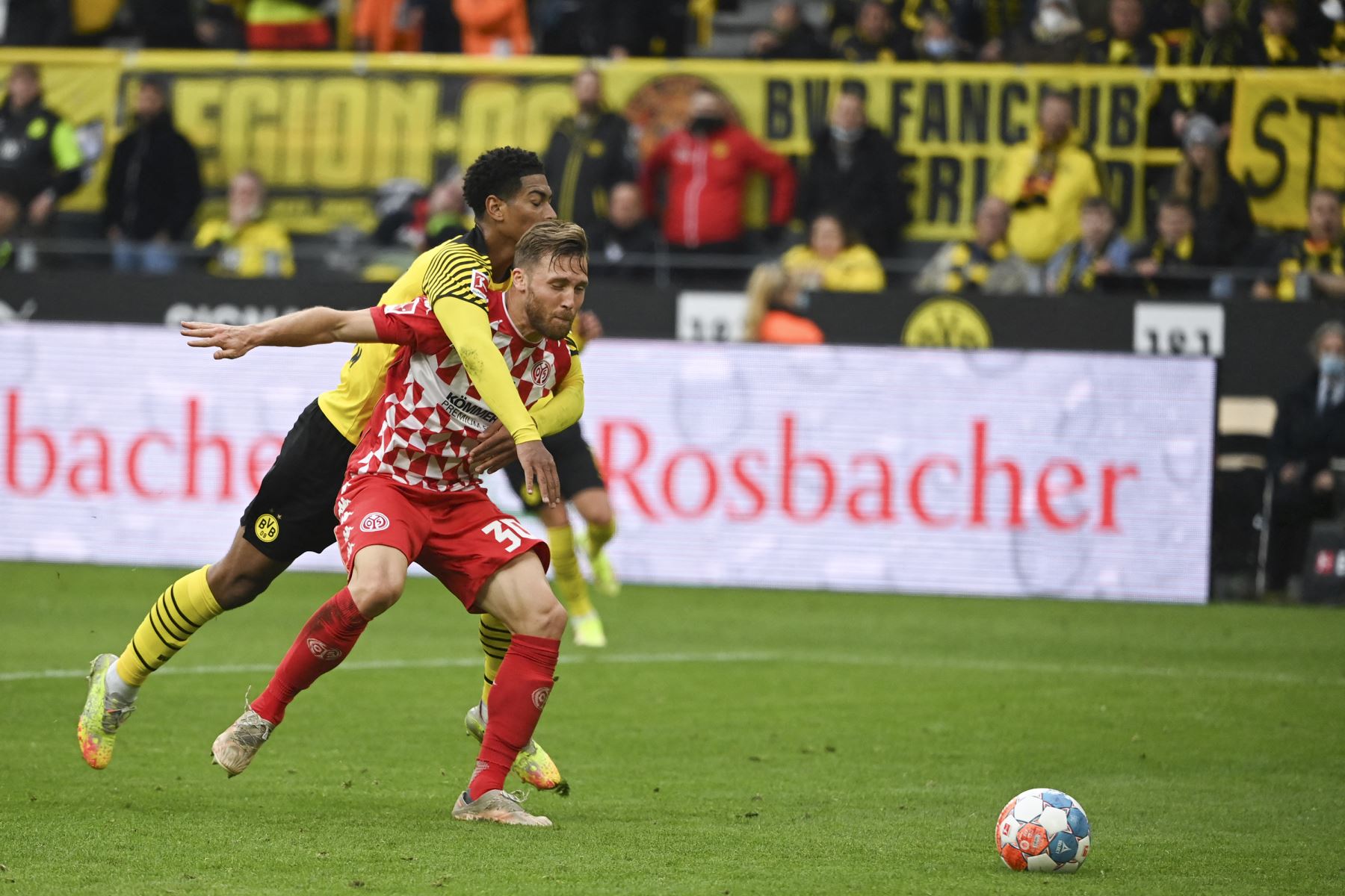 El centrocampista inglés del Dortmund Jude Bellingham y el defensor suizo de Mainz, Silvan Widmer, compiten por el balón durante el partido de la Bundesliga. Foto: AFP