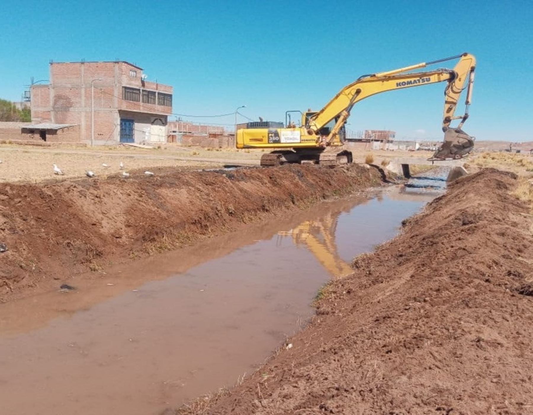 Con apoyo de maquinaria pesada el Ministerio de Vivienda ejecuta labores de descolmatación y limpieza de dren colector de lluvias en distrito de Caracoto, región Puno. ANDINA/Difusión