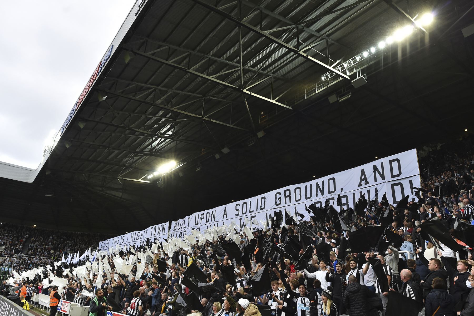 Los fanáticos del Newcastle United ondean banderas y pancartas mientras alientan a su equipo durante el partido ante el Tottenham por la Premier League. Foto: AFP