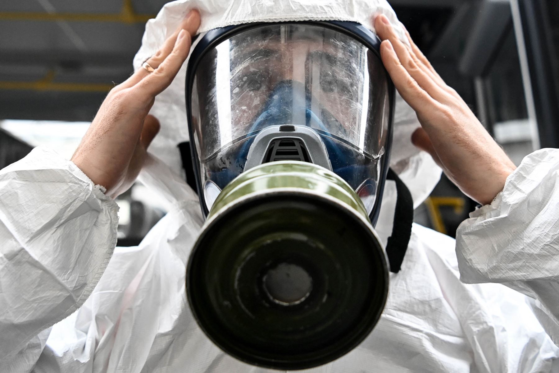 Un militar con equipo de protección ajusta su máscara de gas mientras desinfecta la estación de tren Leningradsky de Moscú. Foto: AFP