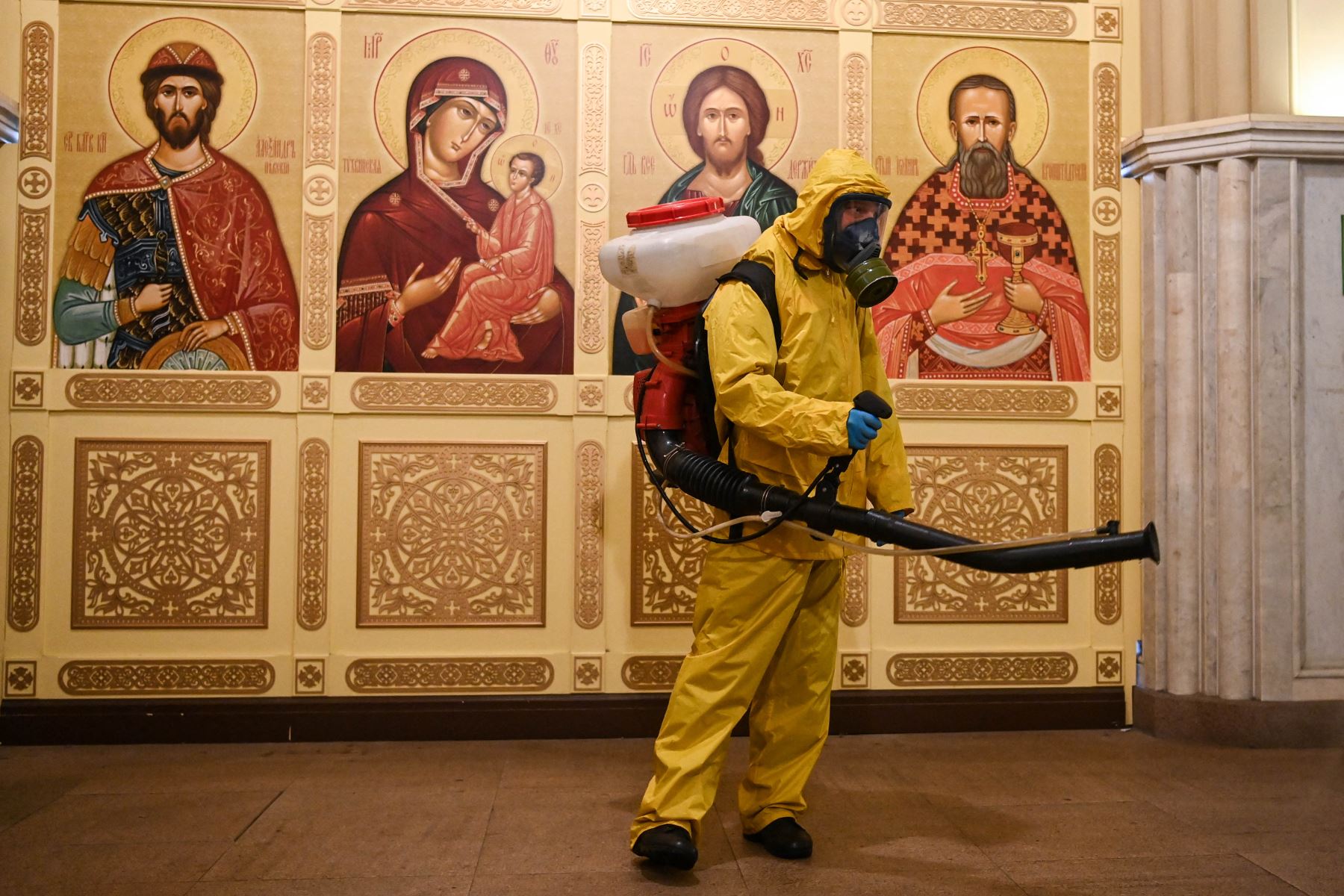 Un militar con equipo de protección desinfecta una capilla ortodoxa en la estación de tren Leningradsky de Moscú. Foto: AFP