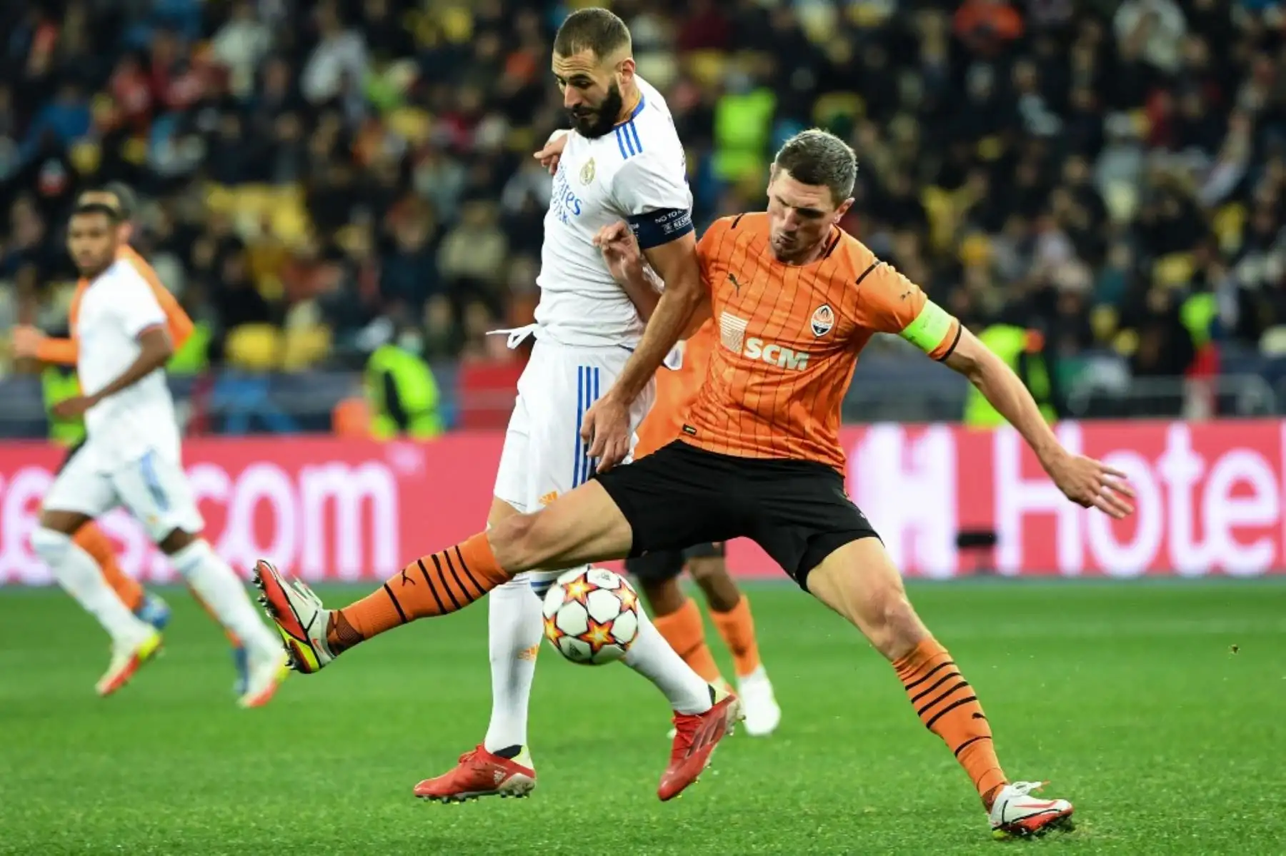 El delantero francés del Real Madrid, Karim Benzema, y el defensor ucraniano del Shakhtar Donetsk, Serhiy Kryvtsov, disputan el balón durante el partido de fútbol de la Liga de Campeones de la UEFA entre el Shakhtar Donetsk y el Real Madrid en el Estadio Olímpico de Kiev el 19 de octubre de 2021. Foto. AFP