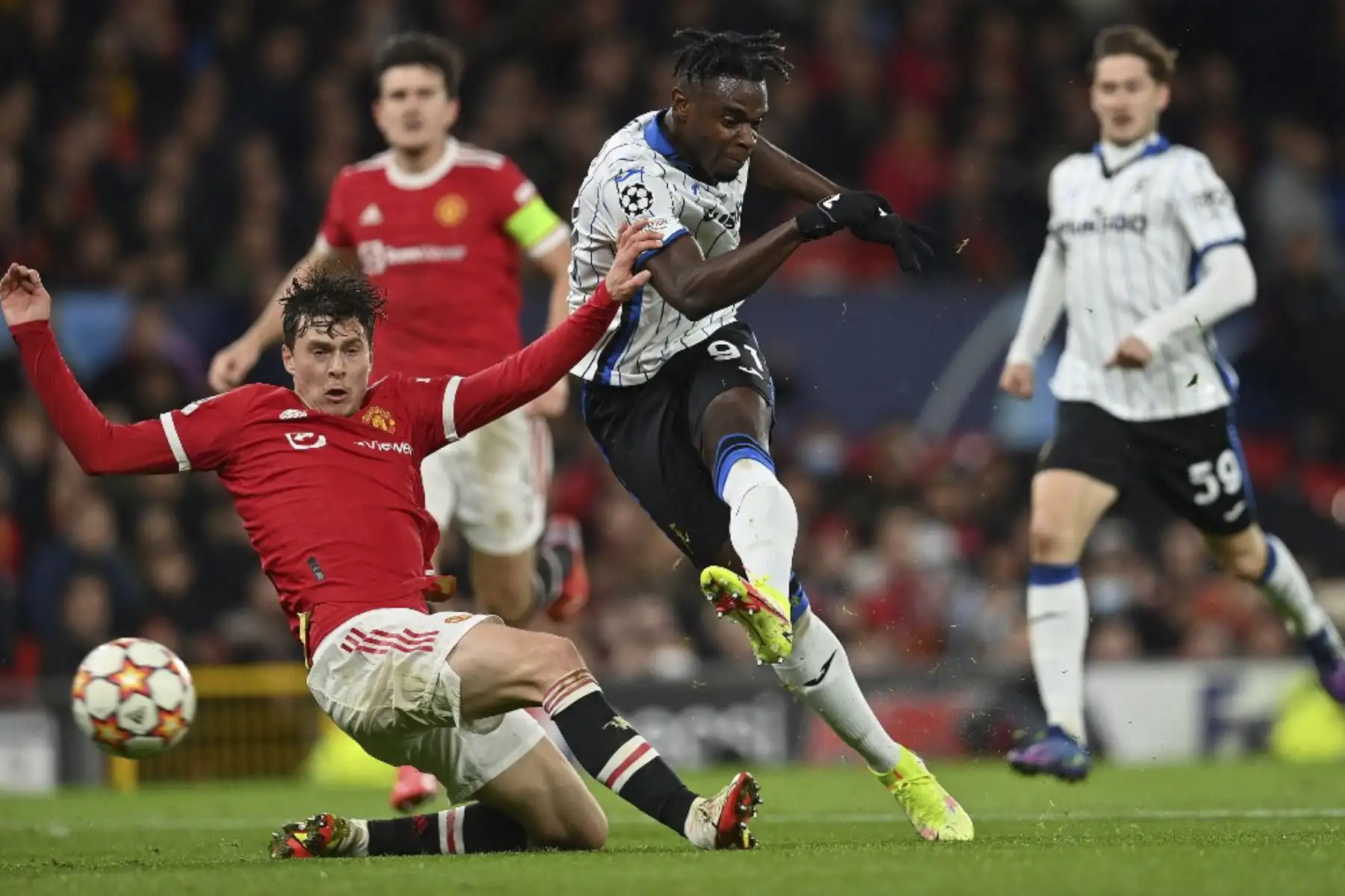 El defensor sueco del Manchester United Victor Lindelof (izq.) Bloquea un disparo del delantero colombiano del Atalanta, Duvan Zapata, durante el partido de fútbol del grupo F de la Liga de Campeones de la UEFA entre el Manchester United y el Atalanta en el estadio Old Trafford en Manchester, noroeste de Inglaterra, el 20 de octubre de 2021. Foto. AFP