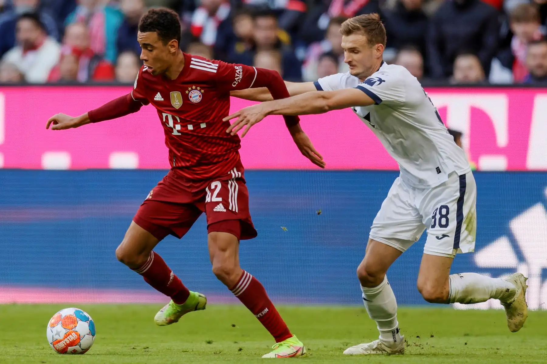 Jamal Musiala de Munich en acción contra Stefan Posch del Hoffenheim durante el partido de la Bundesliga. Foto: EFE