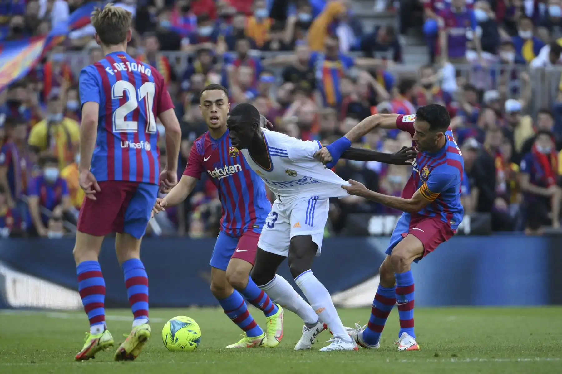 El centrocampista español del Barcelona Sergio Busquets agarra la camiseta del defensor francés del Real Madrid Ferland Mendy durante el partido de la Liga. Foto: AFP