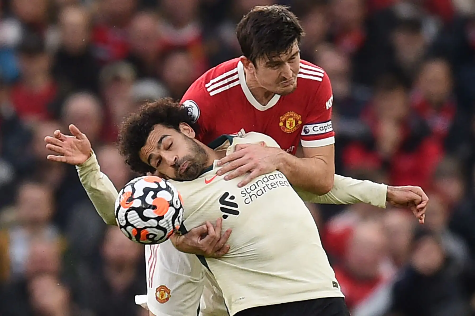 El centrocampista egipcio del Liverpool, Mohamed Salah, compite con el defensor inglés del Manchester United, Harry Maguire durante el partido de la Premier League. Foto: AFP