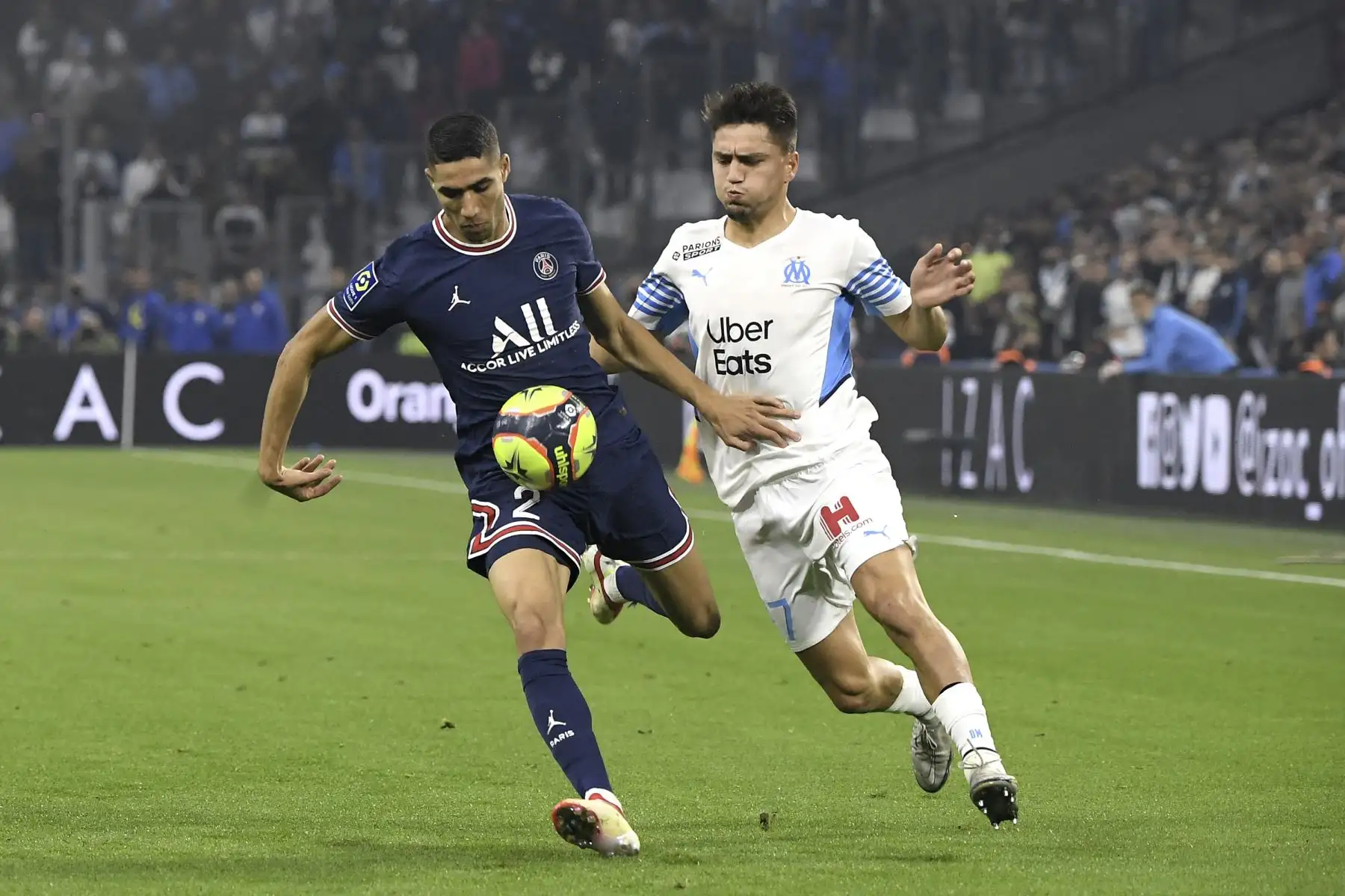 El defensor marroquí del Paris Saint-Germain Achraf Hakimi lucha por el balón con el delantero turco del Marsella Cengiz Under durante el partido de la Liga francesa. Foto. AFP