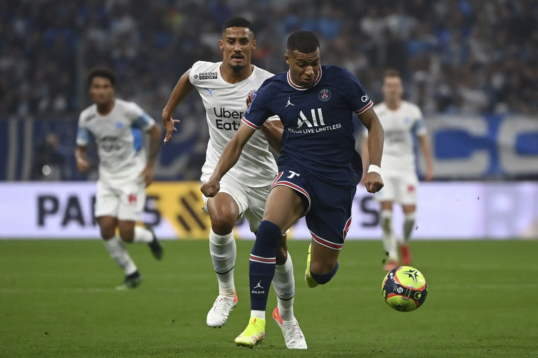 El delantero francés del Paris Saint-Germain, Kylian Mbappé, disputa el balón con el defensor francés del Marsella, William Saliba, durante el partido del fútbol francés. Foto: AFP