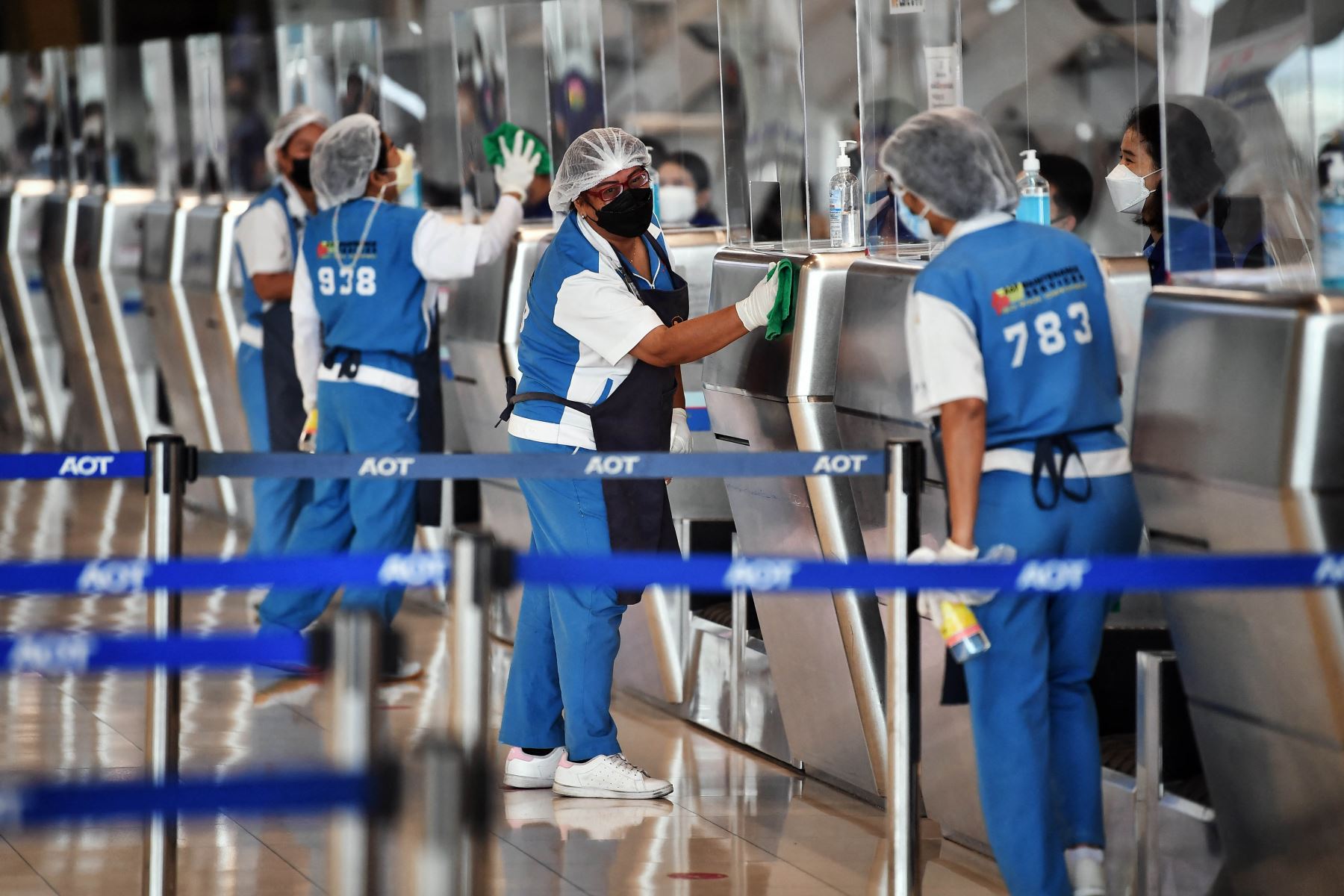 El personal del aeropuerto limpia los quioscos de facturación en el aeropuerto internacional de Suvarnabhumi mientras los funcionarios ensayan los procedimientos de reapertura para recibir al primer grupo de turistas vacunados sin cuarentena. Foto: AFP