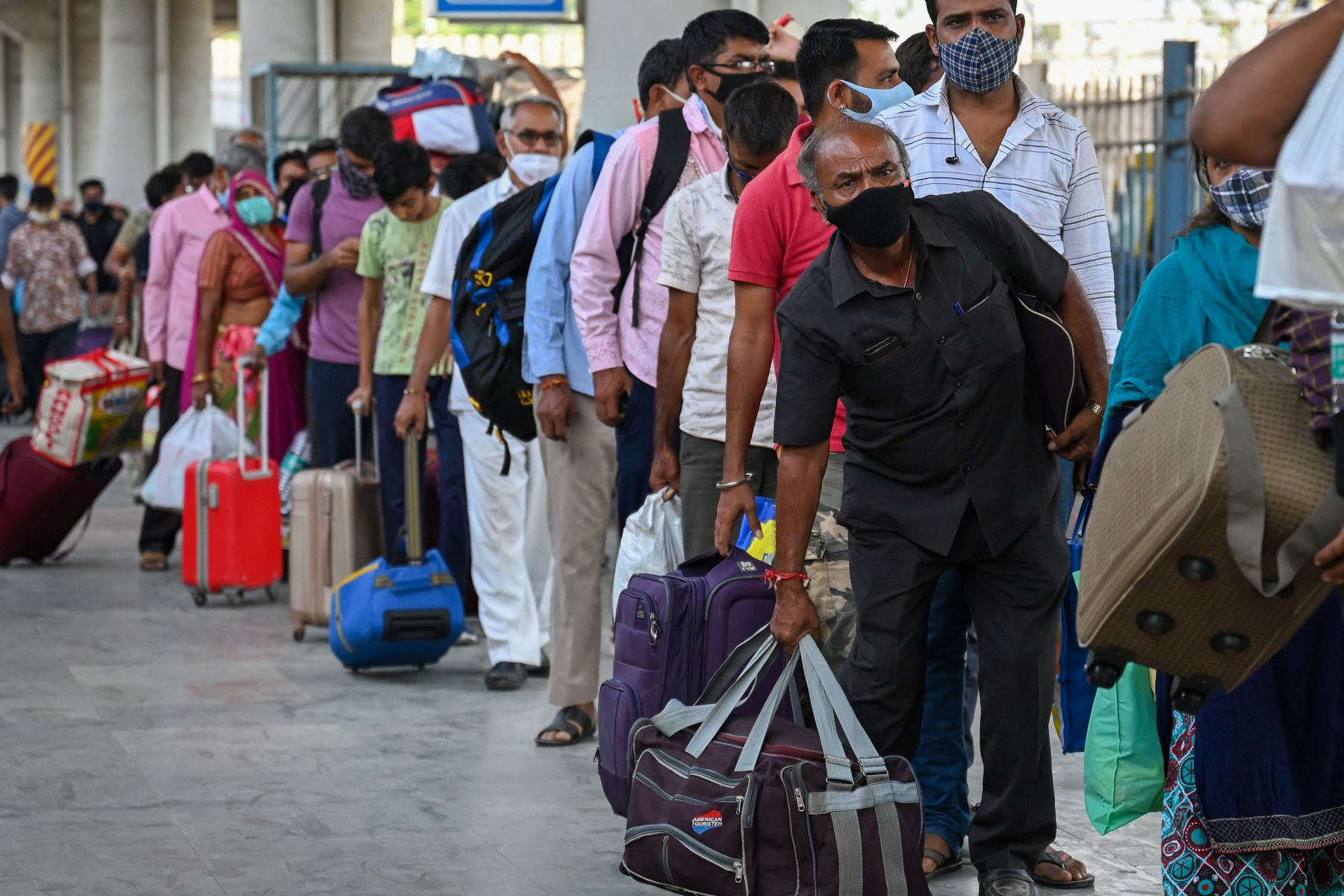 Los pasajeros hacen cola para que les controlen la temperatura durante una prueba de detección del coronavirus Covid-19 después de llegar a una plataforma ferroviaria en un tren de larga distancia, en Mumbai.
Foto: AFP