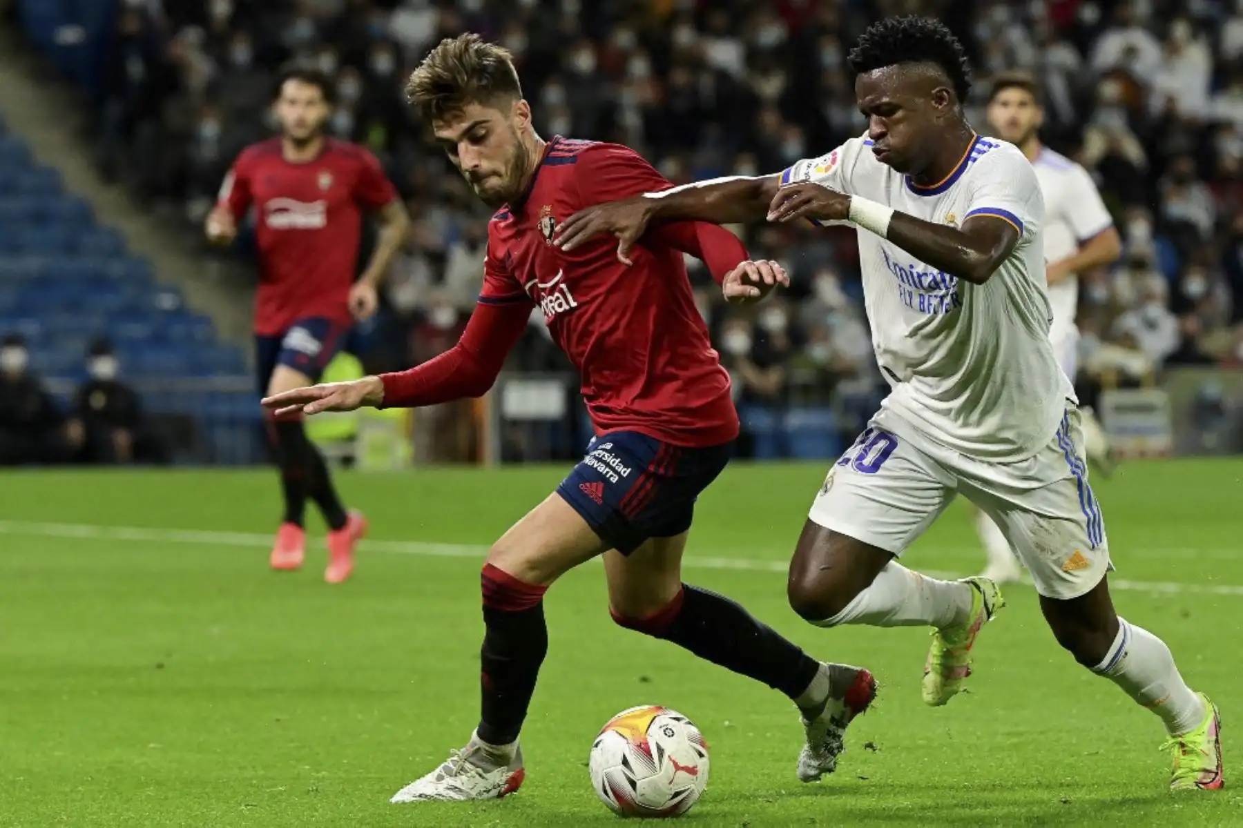 El defensor español de Osasuna, Nacho Vidal (L), lucha por el balón con el delantero brasileño del Real Madrid Vinicius Junior durante el partido de fútbol de la Liga española entre el Real Madrid CF y el CA Osasuna en el estadio Santiago Bernabeu de Madrid el 27 de octubre de 2021. Foto: AFP