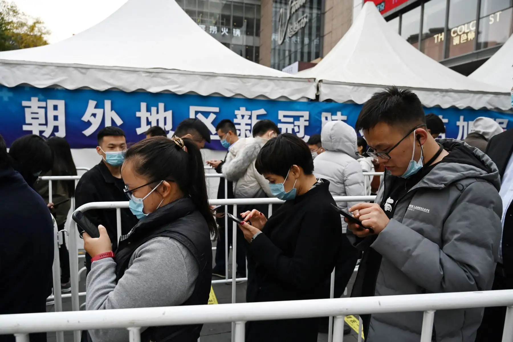 La gente hace fila para recibir una inyección de refuerzo de la vacuna contra la Covid-19 en una tienda de campaña instalada fuera de un centro comercial en Beijing. Foto: AFP