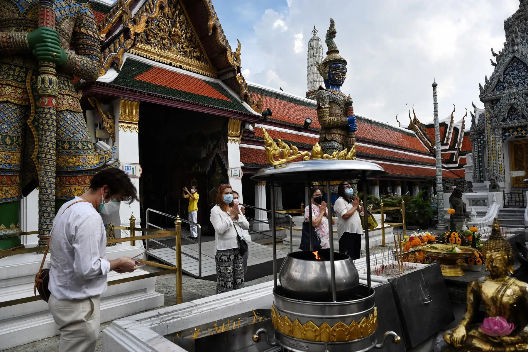 Visitantes locales rezan en el Gran Palacio el día de la reapertura en Bangkok. Tailandia da la bienvenida a los primeros grupos de turistas completamente vacunados contra el coronavirus sin cuarentena. Foto: AFP
