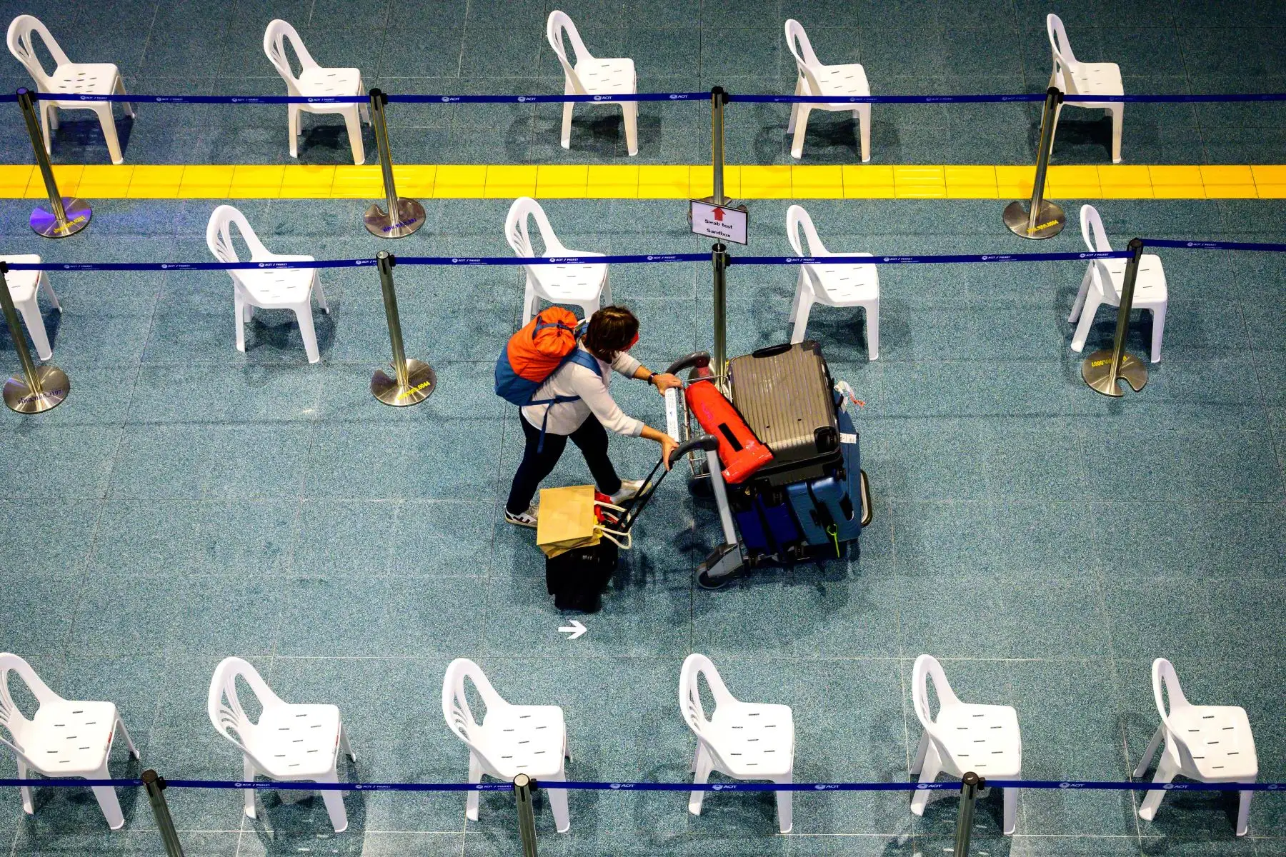 Una mujer camina por el área de llegada del Aeropuerto Internacional de Phuket mientras Tailandia recibe al primer grupo de turistas completamente vacunados contra el coronavirus. Foto: AFP