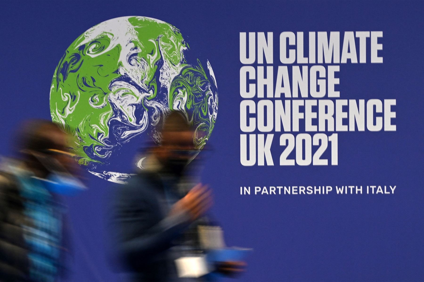 Los delegados pasan un cartel para la Conferencia de las Naciones Unidas sobre el cambio climático en el Reino Unido 2021, durante la cumbre COP26 en Glasgow, Escocia.
Foto: AFP
