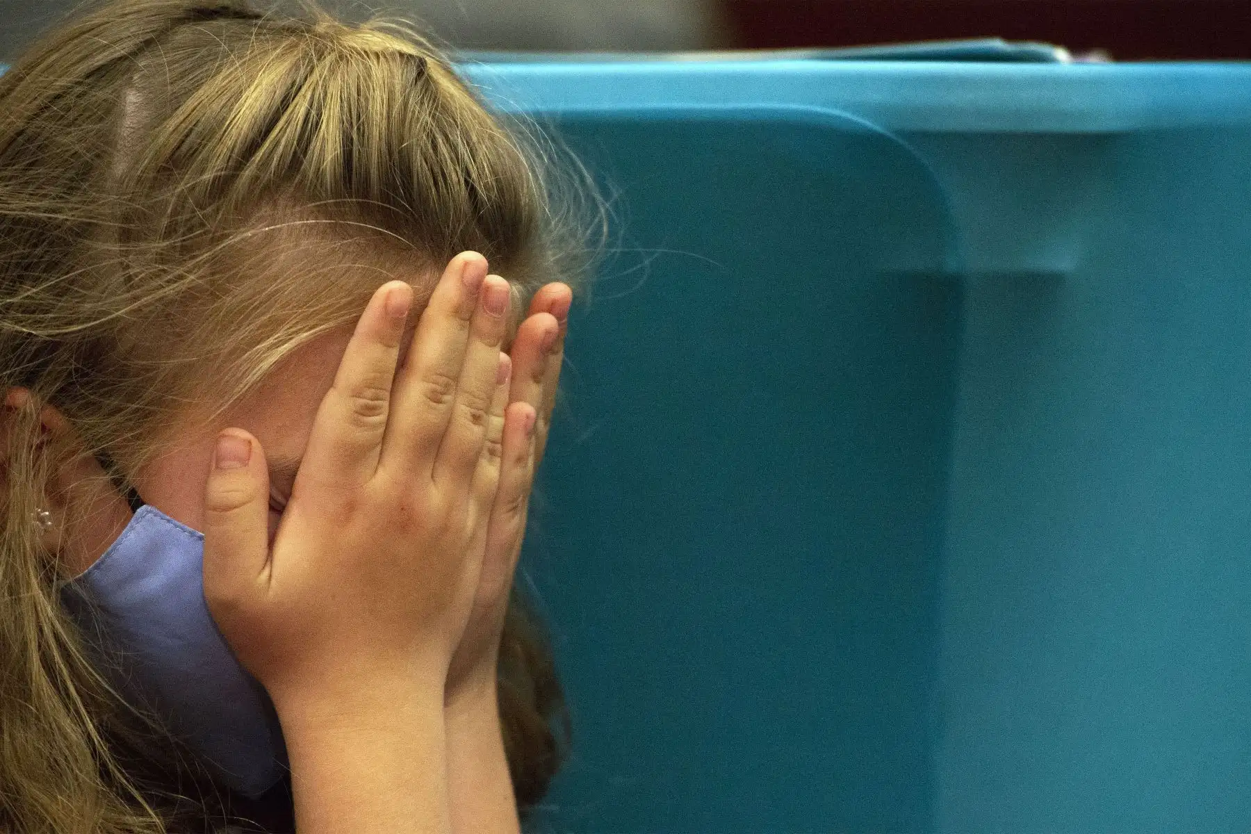 Una niña se cubre la cara mientras espera su turno para recibir la vacuna, en Connecticut,  Estados Unidos.
Foto : AFP