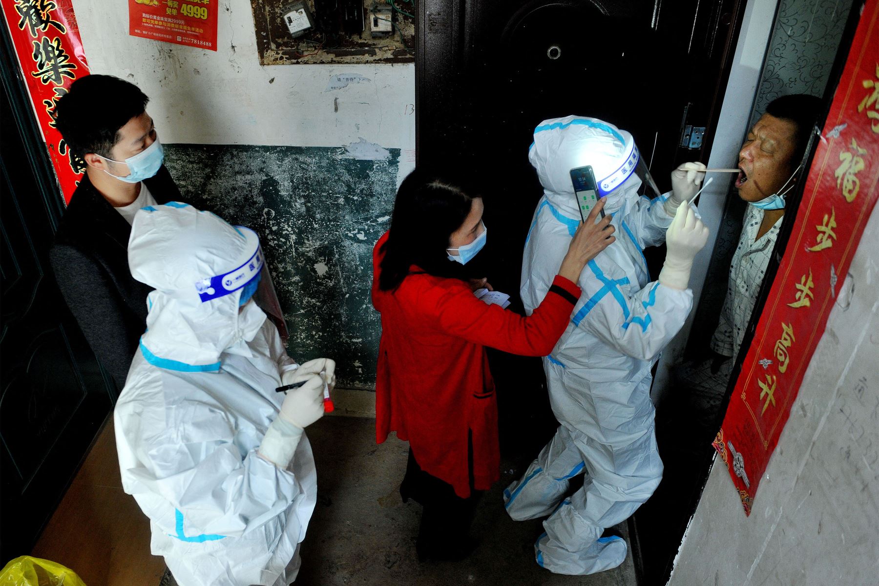 Funcionarios y trabajadores médicos realizan una prueba de coronavirus covid-19 en un residente que se aísla en su casa luego del reciente brote de coronavirus en Dexing, en la provincia central de Jiangxi.
Foto : AFP