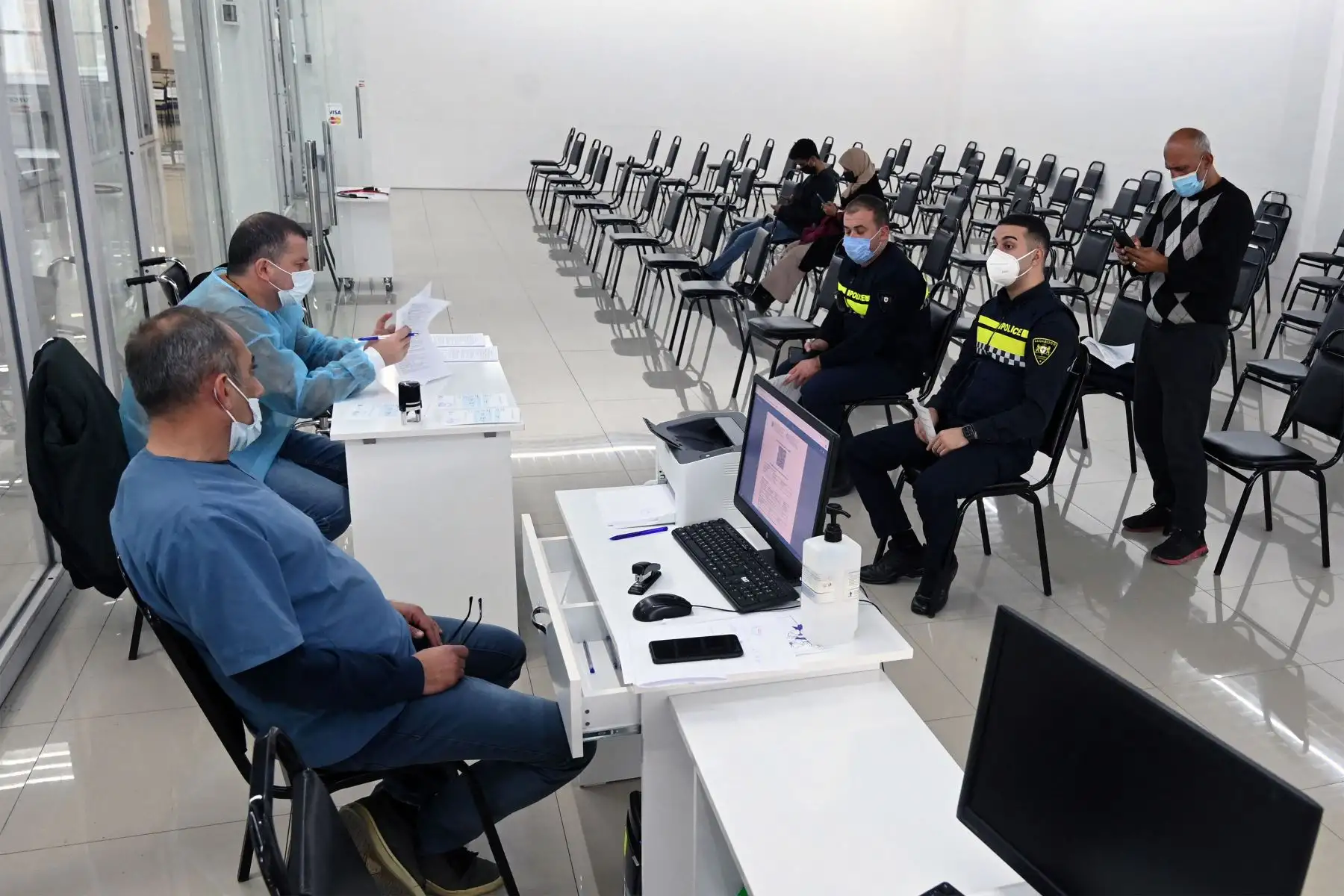 Los pacientes se sientan en una sala de espera antes de recibir una inyección de vacuna contra el covid-19, en un centro de vacunación ubicado en una zona comercial en Tbilisi,  Georgia.
Foto : AFP