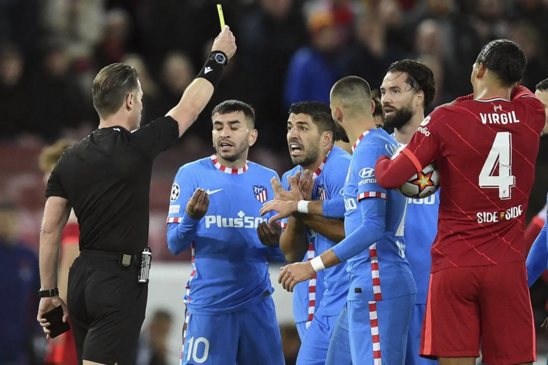 El árbitro Danny Makkelie muestra una tarjeta amarilla al delantero uruguayo del Atlético de Madrid Luis Suárez después de expulsar al defensor brasileño del Atlético de Madrid Felipe (invisible) durante el partido de fútbol del grupo B de la Liga de Campeones de la UEFA entre el Liverpool y el Atlético de Madrid en Anfield en Liverpool, noroeste de Inglaterra el 3 de noviembre. Foto: AFP