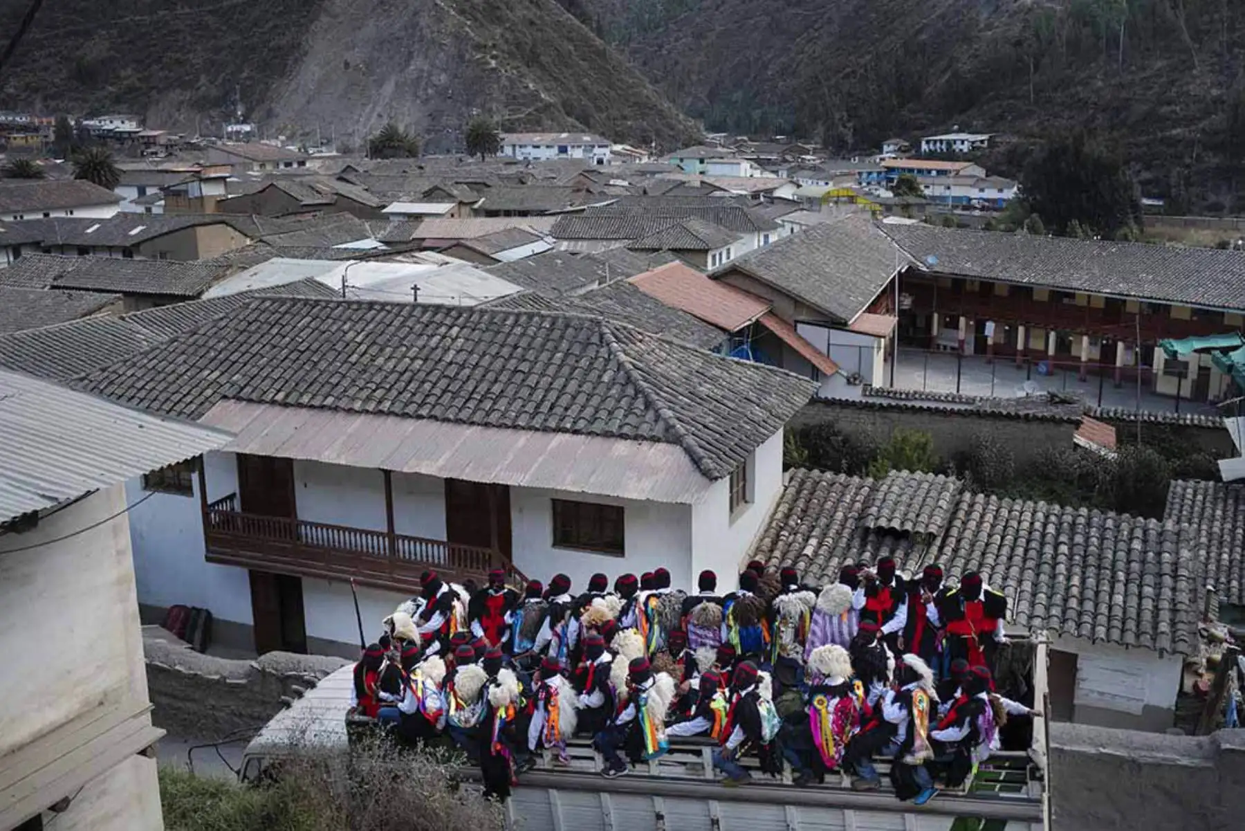 Desde Mayahuani se inicia un camino empinado de ocho kilometors que culebrea en las montañas. Se observa las tejas de los techos del pueblo de Paucartambo. Fotografía del libro, Qoyllurit