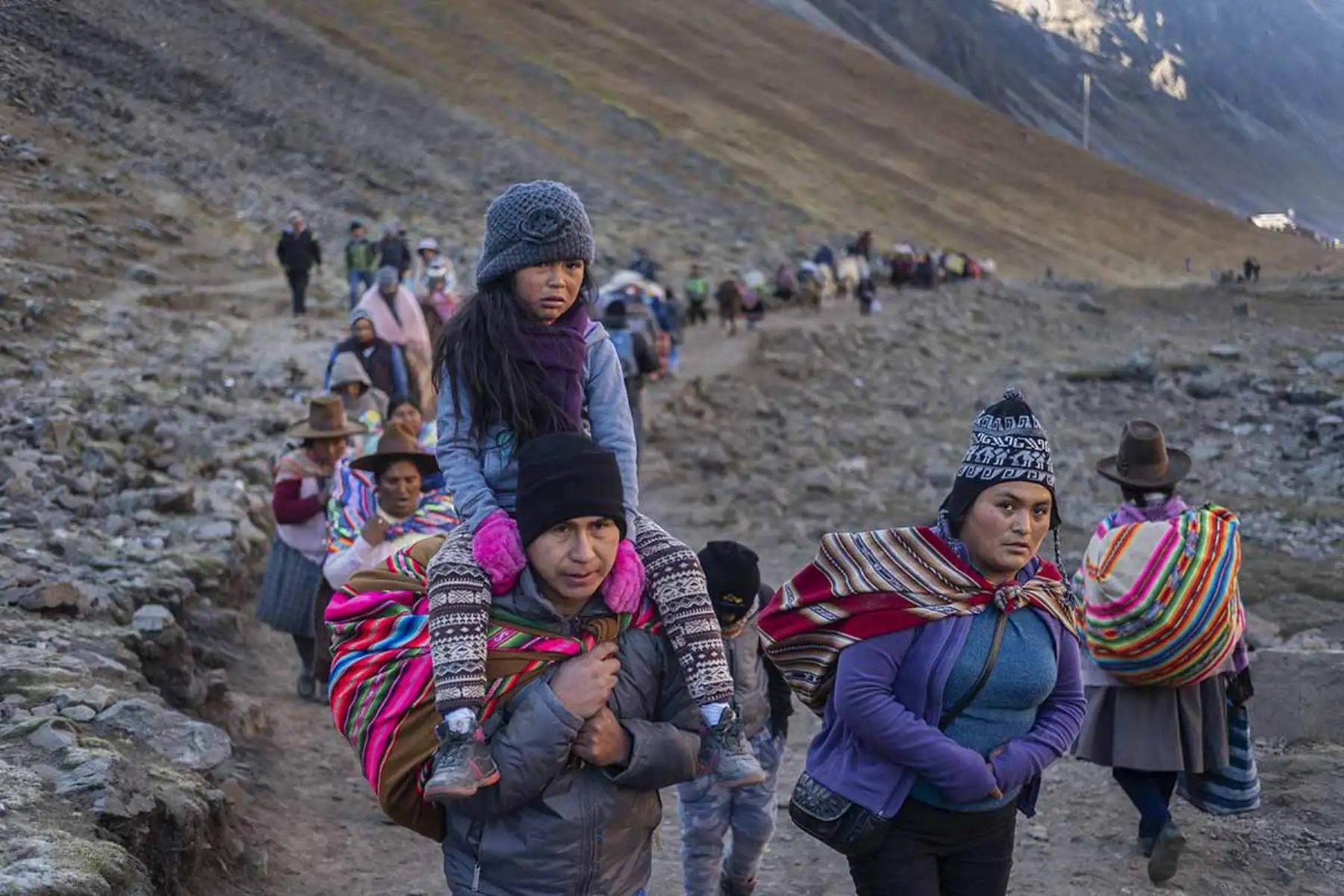 Un hombre carga a su hija durante el ascenso al Santuario.Fotografía del libro, Qoyllurit