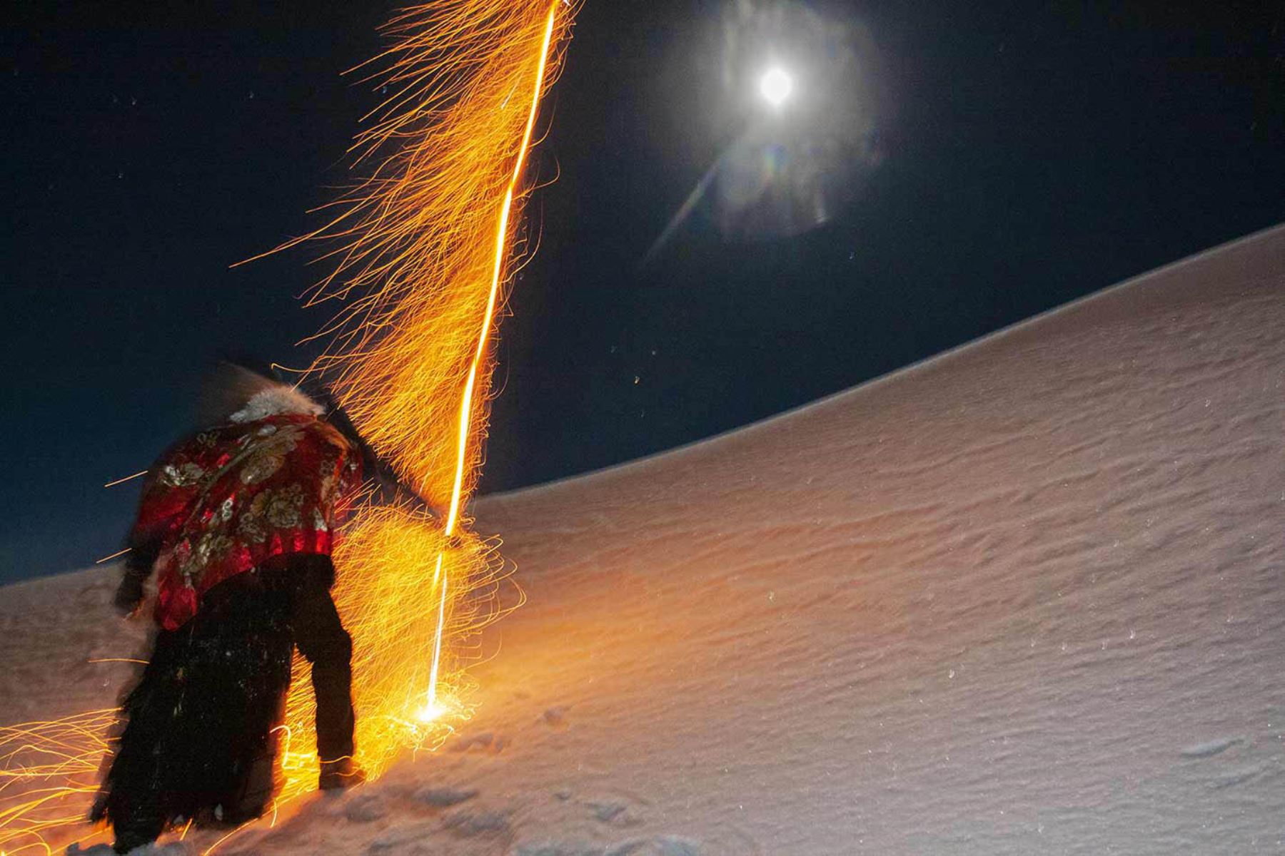 Pasada la media noche un Ukuku lanza un cohete durante el ascenso al nevado Qolquepunku.Fotografía del libro, Qoyllurit